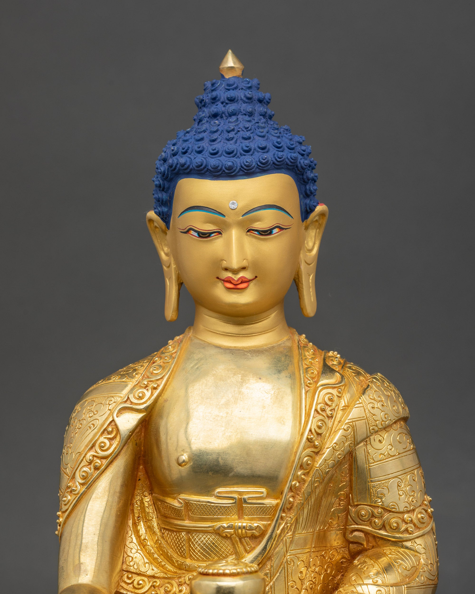 Close-up of Buddha statue face, gold-painted features exuding calm and enlightenment