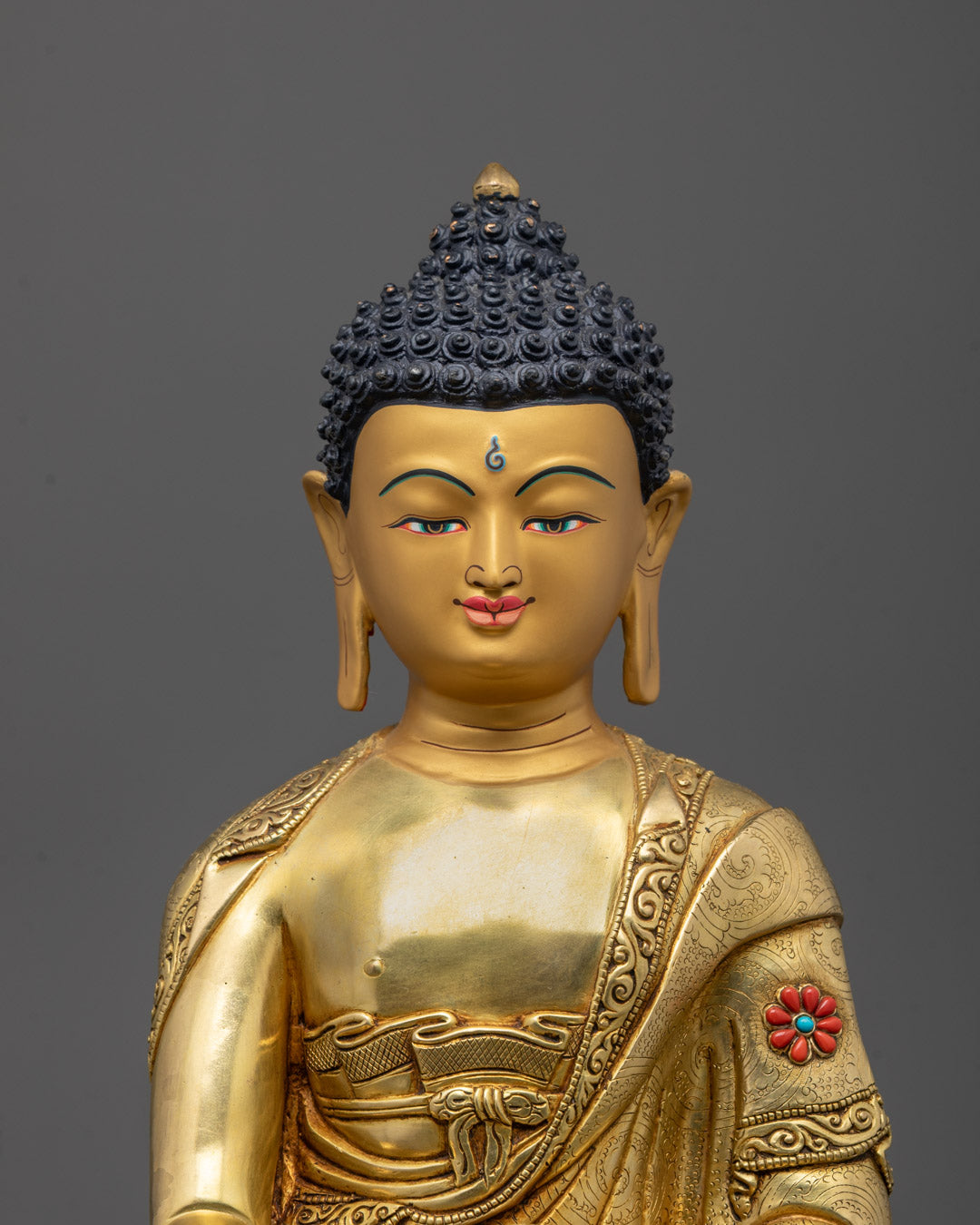 Close-up of Buddha statue’s radiant gold face and semi-precious stone decorations