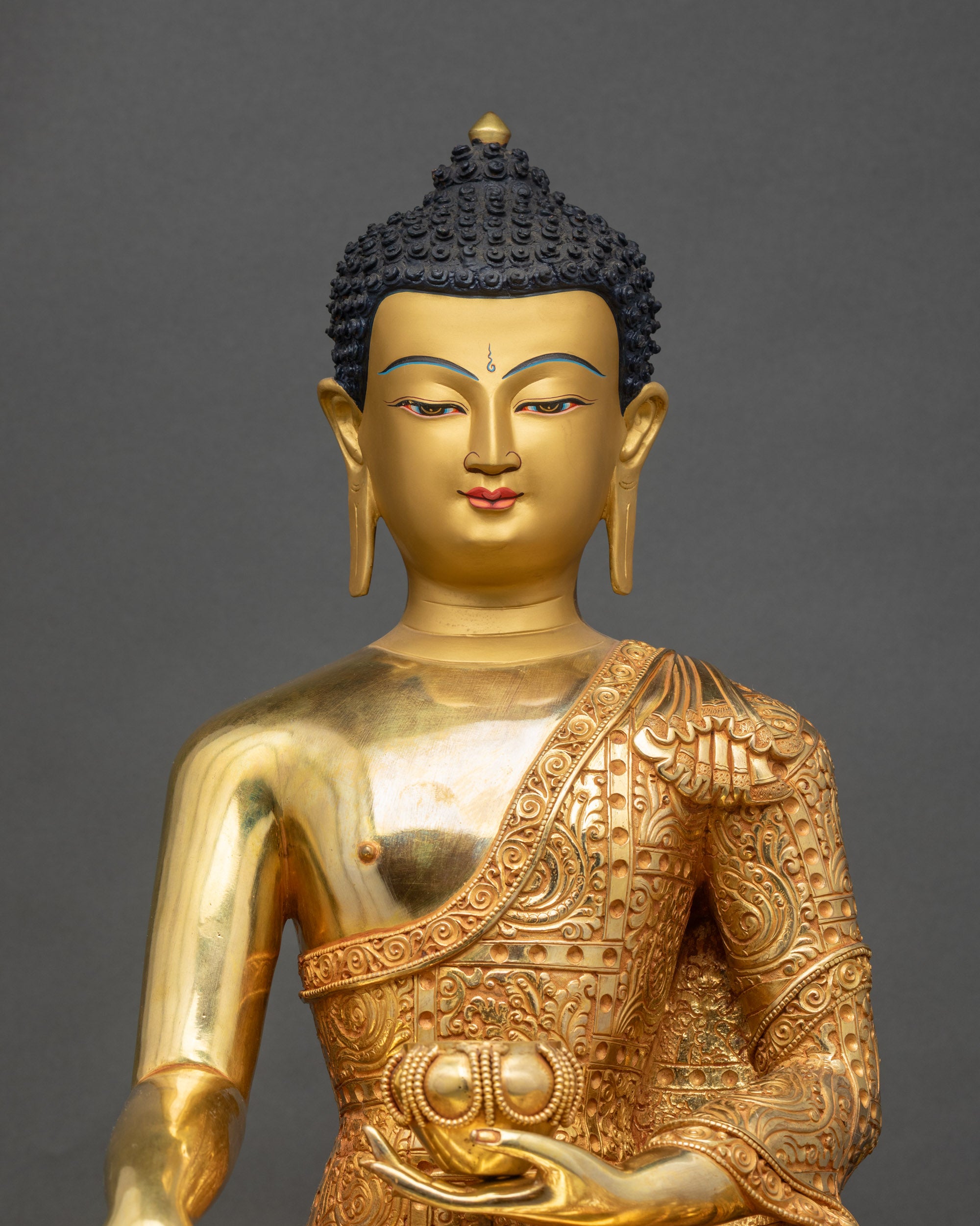 Close-up of Buddha statue showing detailed carvings and serene golden face with divine halo