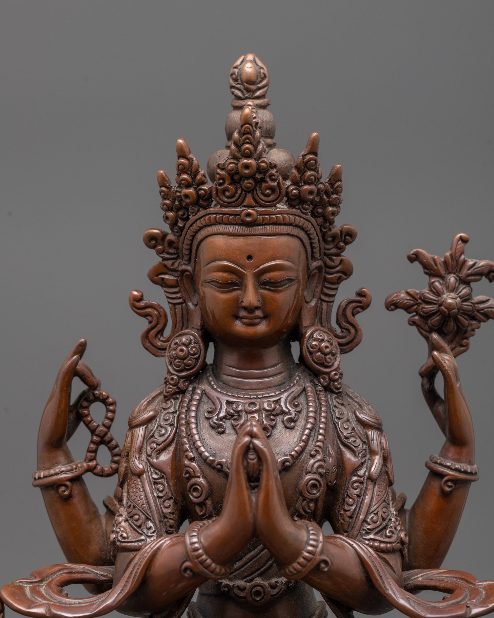 Close-up of Chenrezig's serene face and intricate crown design, showcasing statue