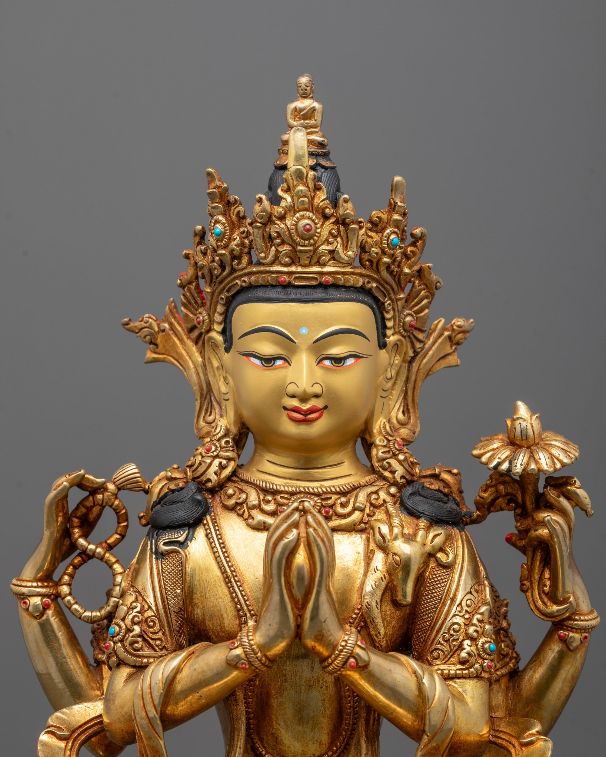 Close-up of Chenrezig statue’s 24K gold-gilded face and intricate semi-precious stone details