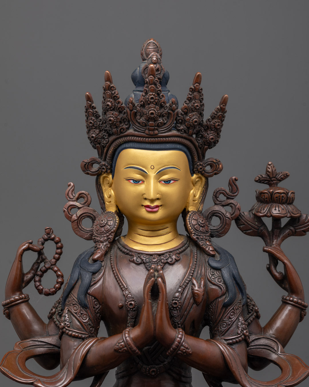 Close-up of Chenrezig statue's serene facial expression and intricate hand-carved