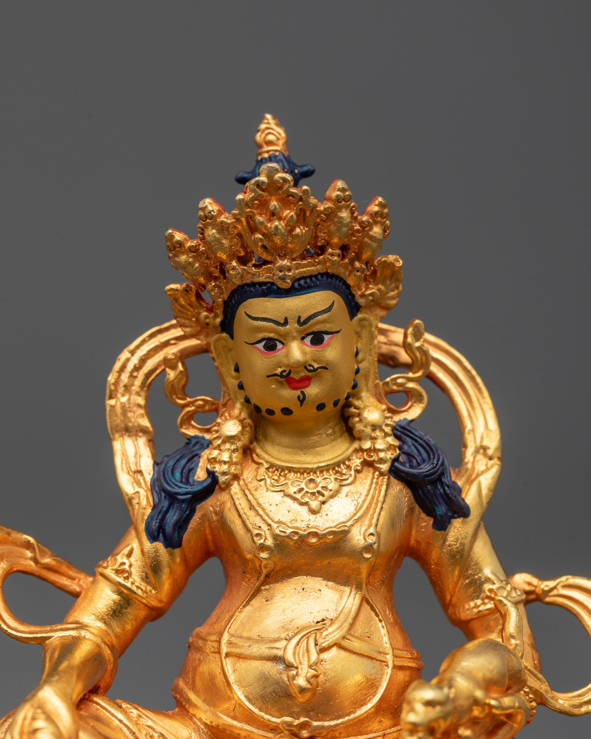 Close-up of Dzambhala Statue featuring intricate gold-plated details