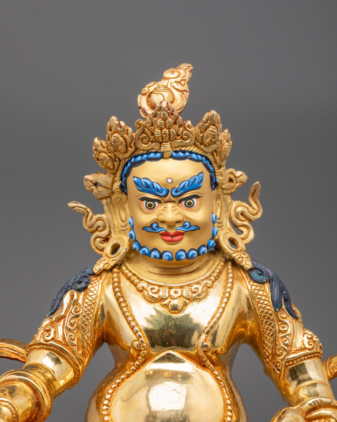 Close-up of Dzambhala's ornate crown, jewelry, and acrylic-painted details