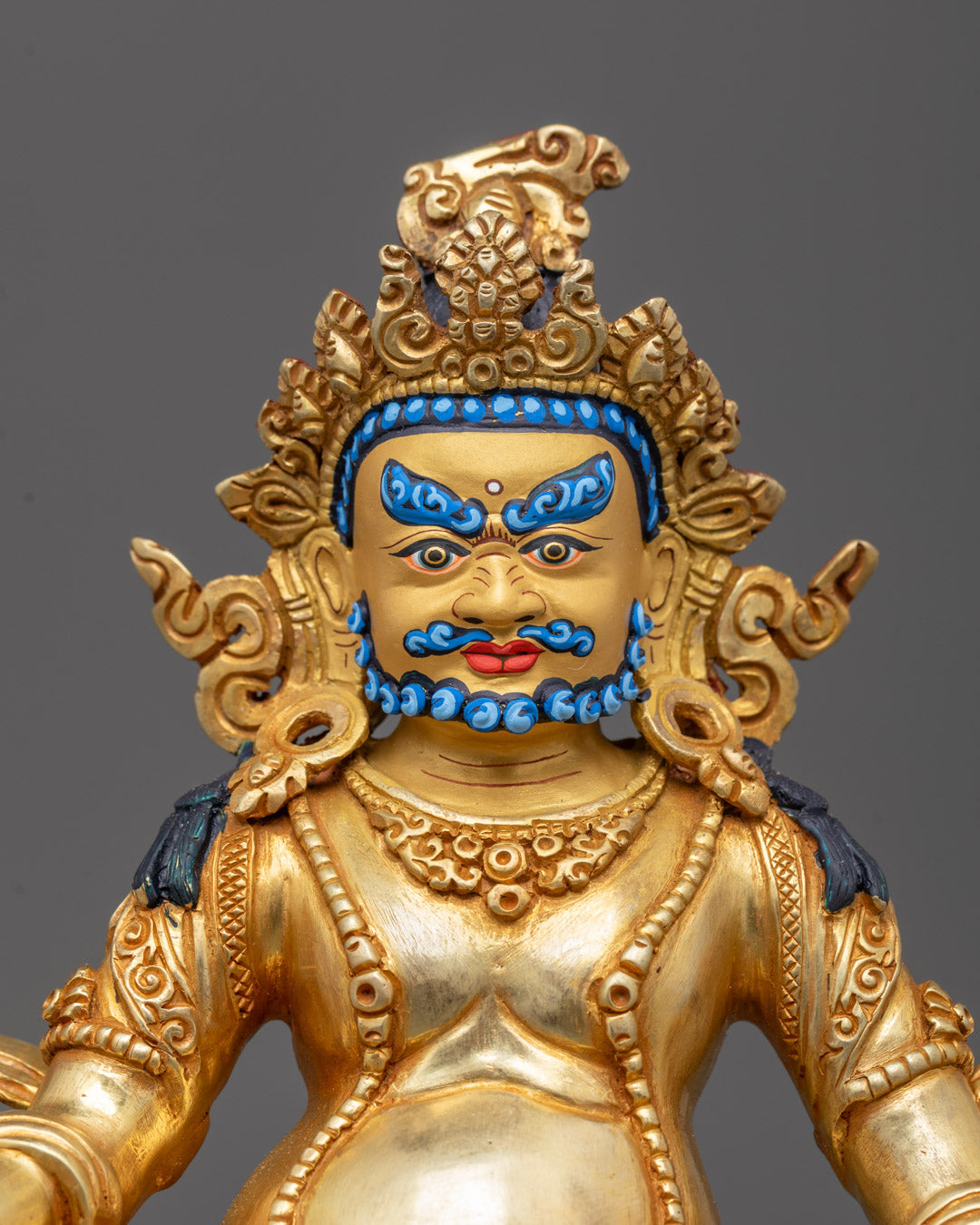 Close-up of Dzambhala sculpture lotus throne and fire-gilded body details