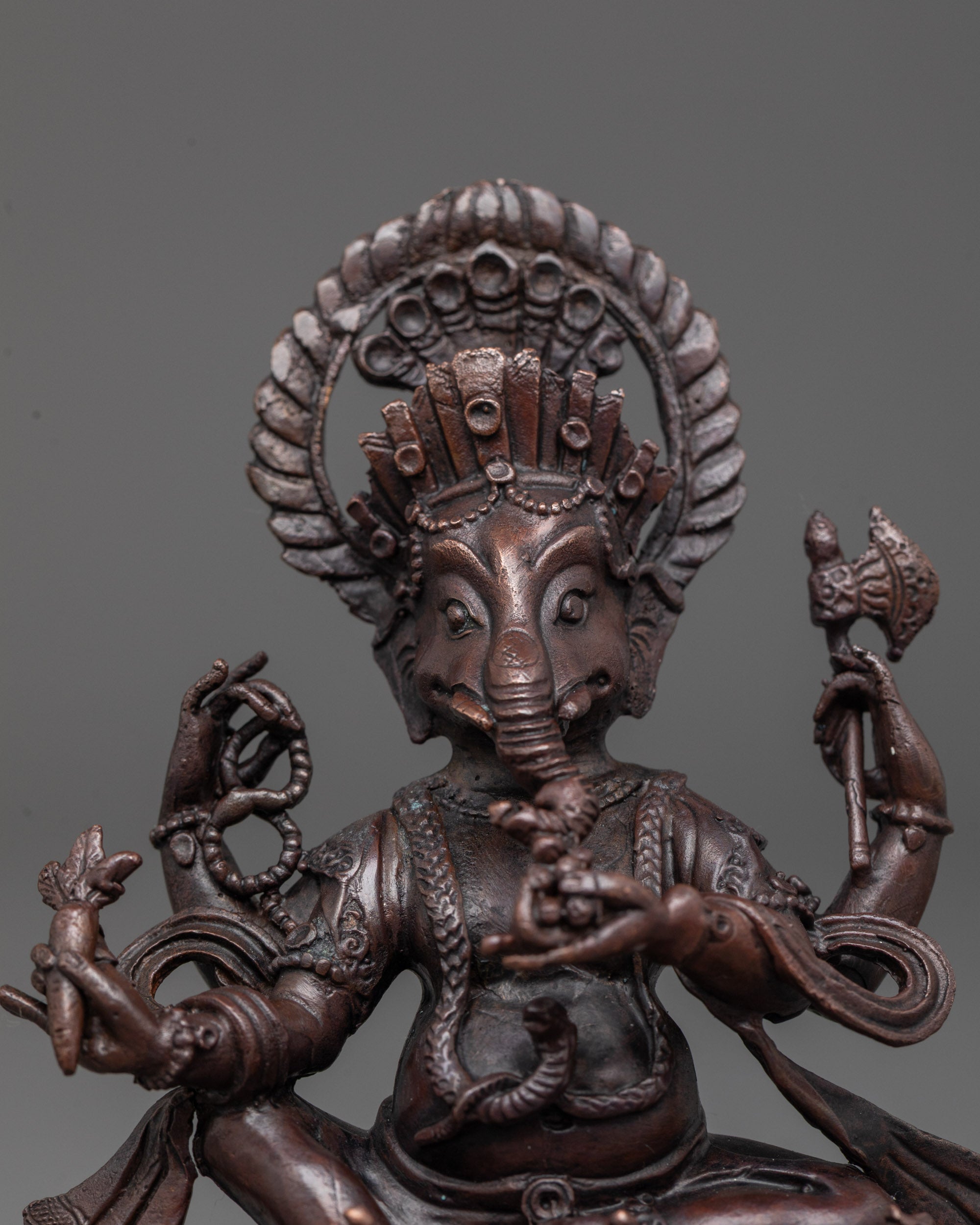 Close-up of Ganesha's oxidized copper face showing intricate electroplated detailing