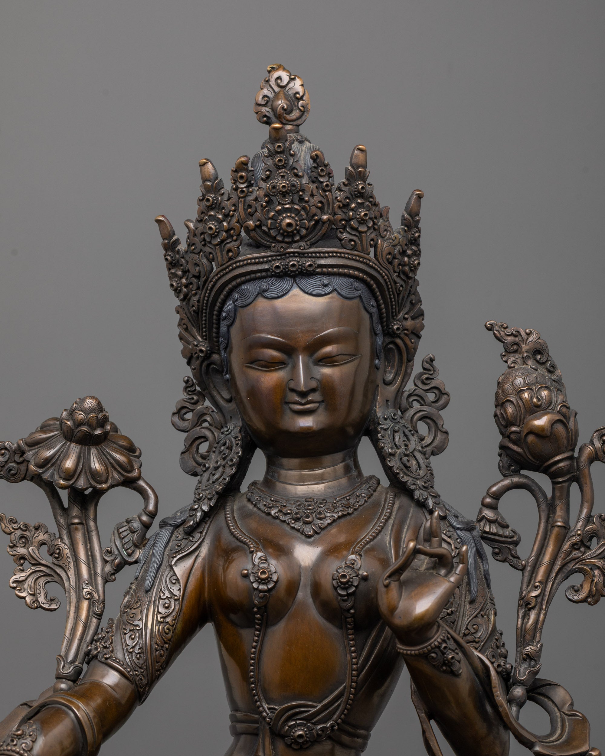 Close-up of Green Tara face showing oxidized copper finish and compassionate detailing