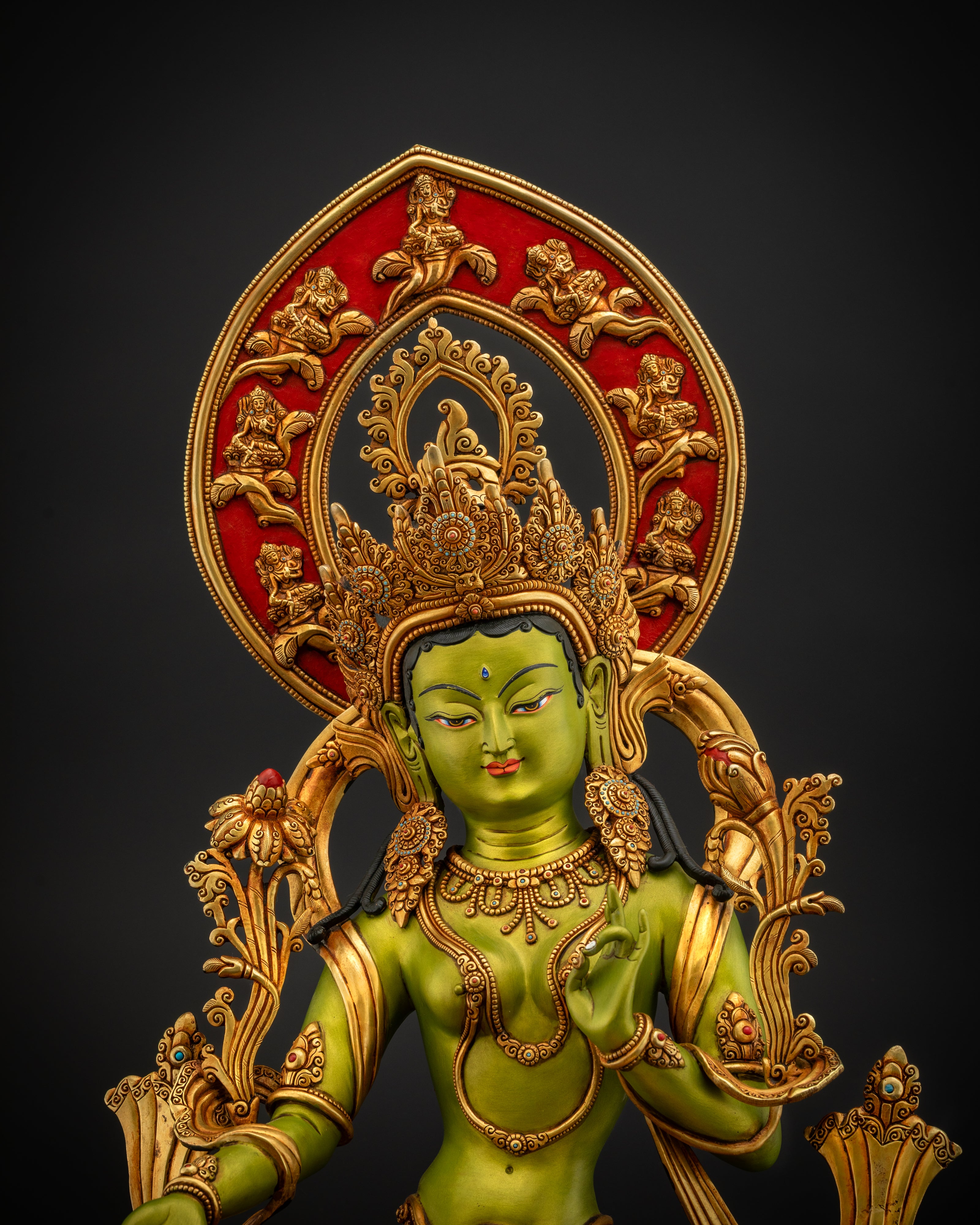 Close-up of Green Tara's gold crown, utpala flower, and hand-painted facial features