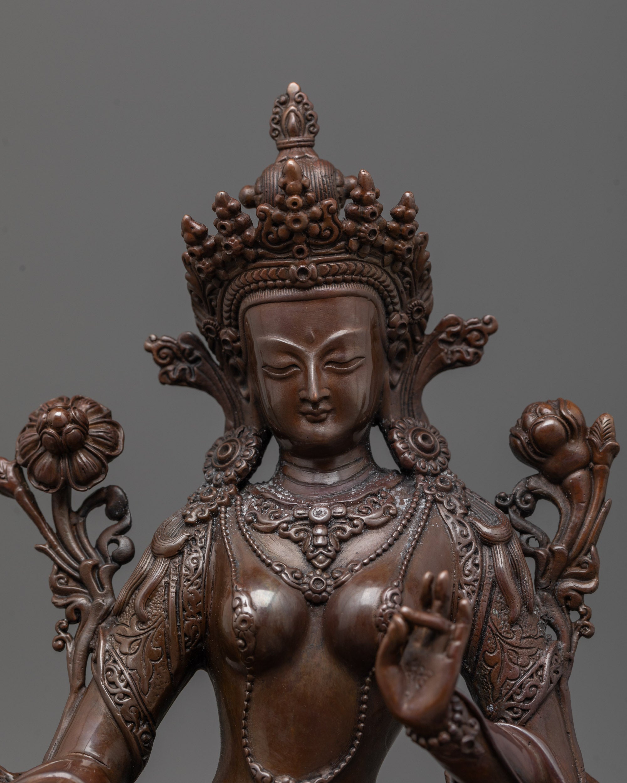 Close-up of Green Tara’s peaceful face and right hand in varada mudra symbolizing compassion