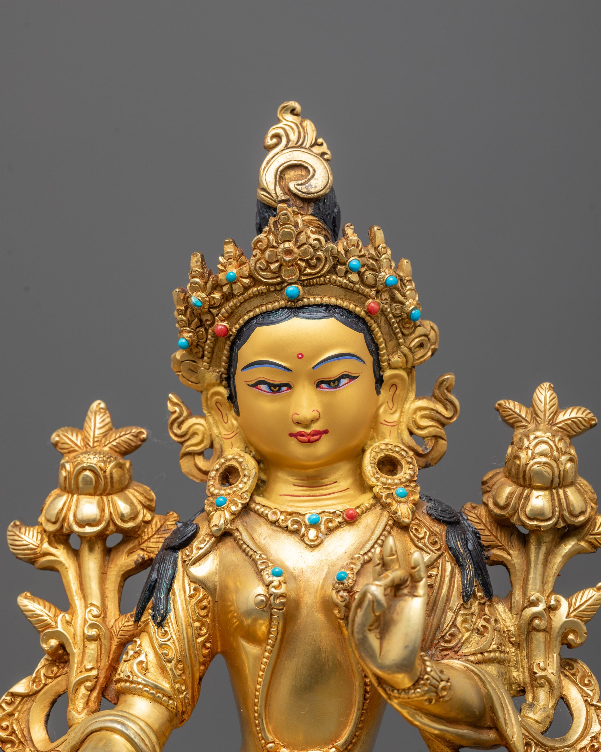 Close-up of Green Tara’s serene face adorned with a finely detailed crown and radiant