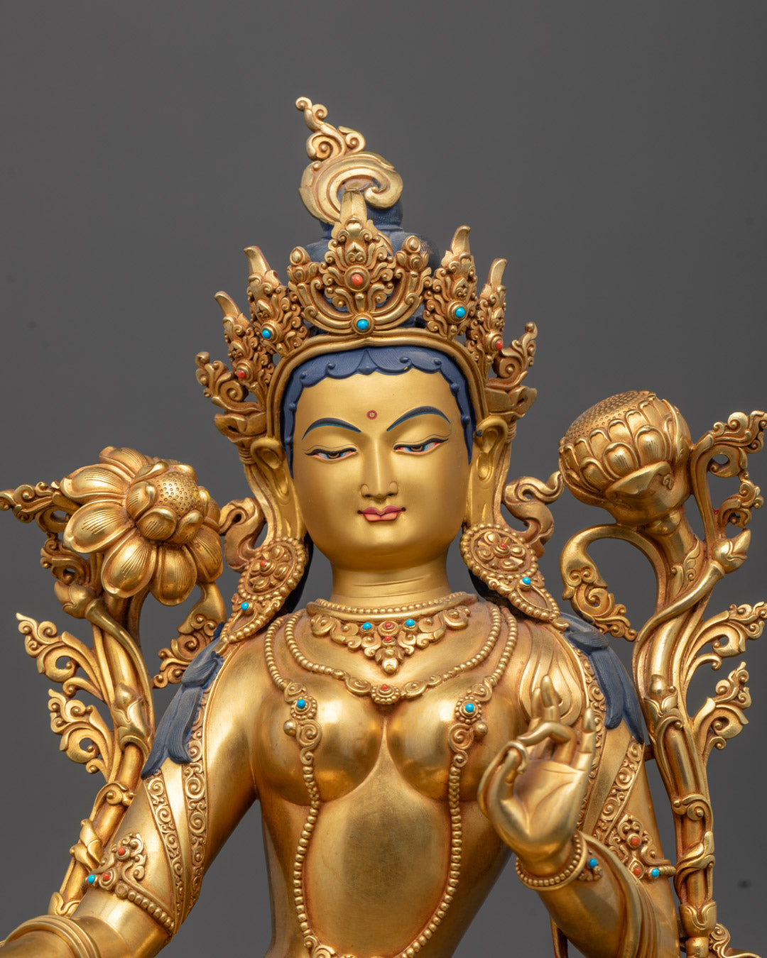 Close-up of Green Tara's serene face and intricate detailing on the golden crown