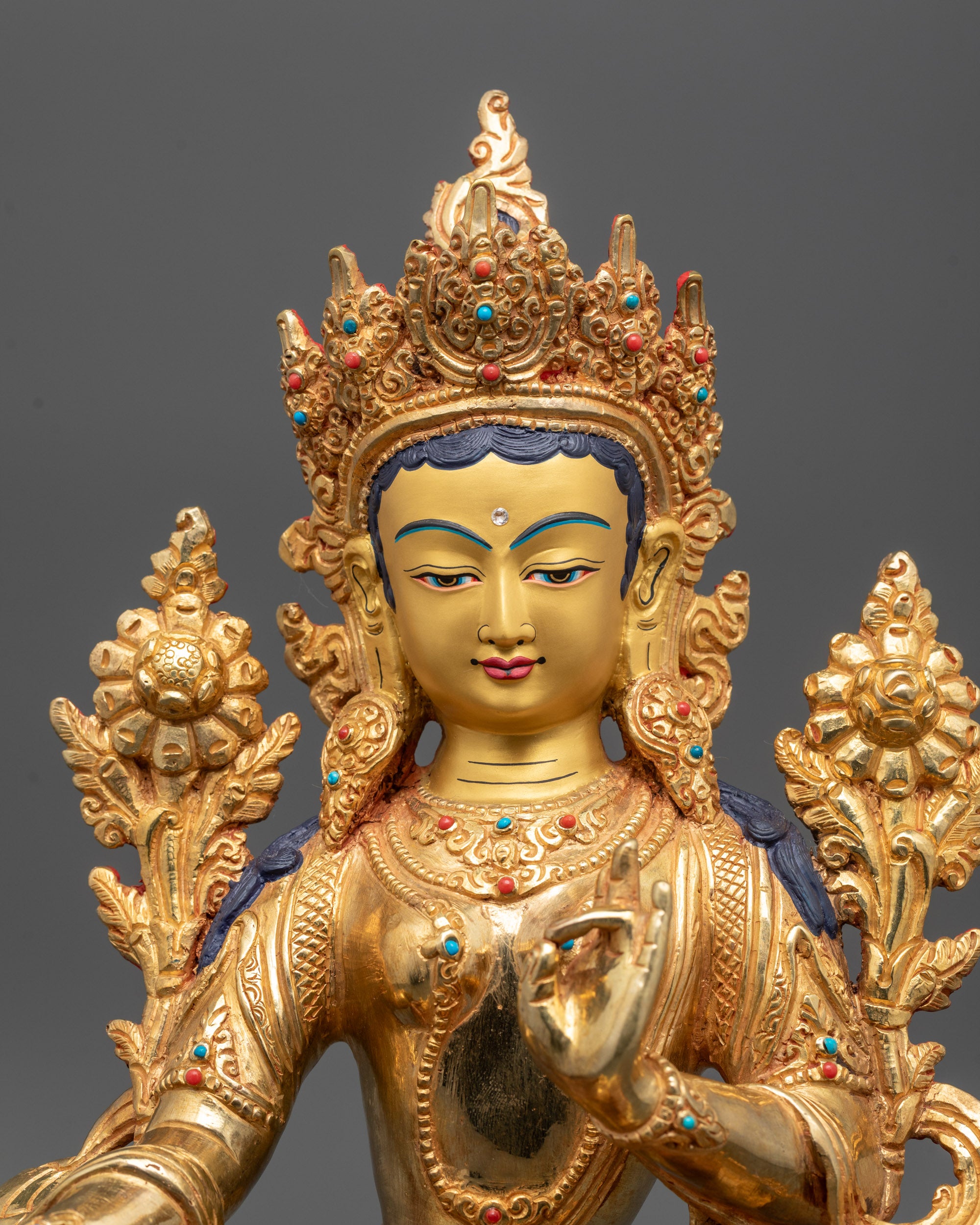 Close-up of Green Tara’s serene face and intricate semi-precious stone crown