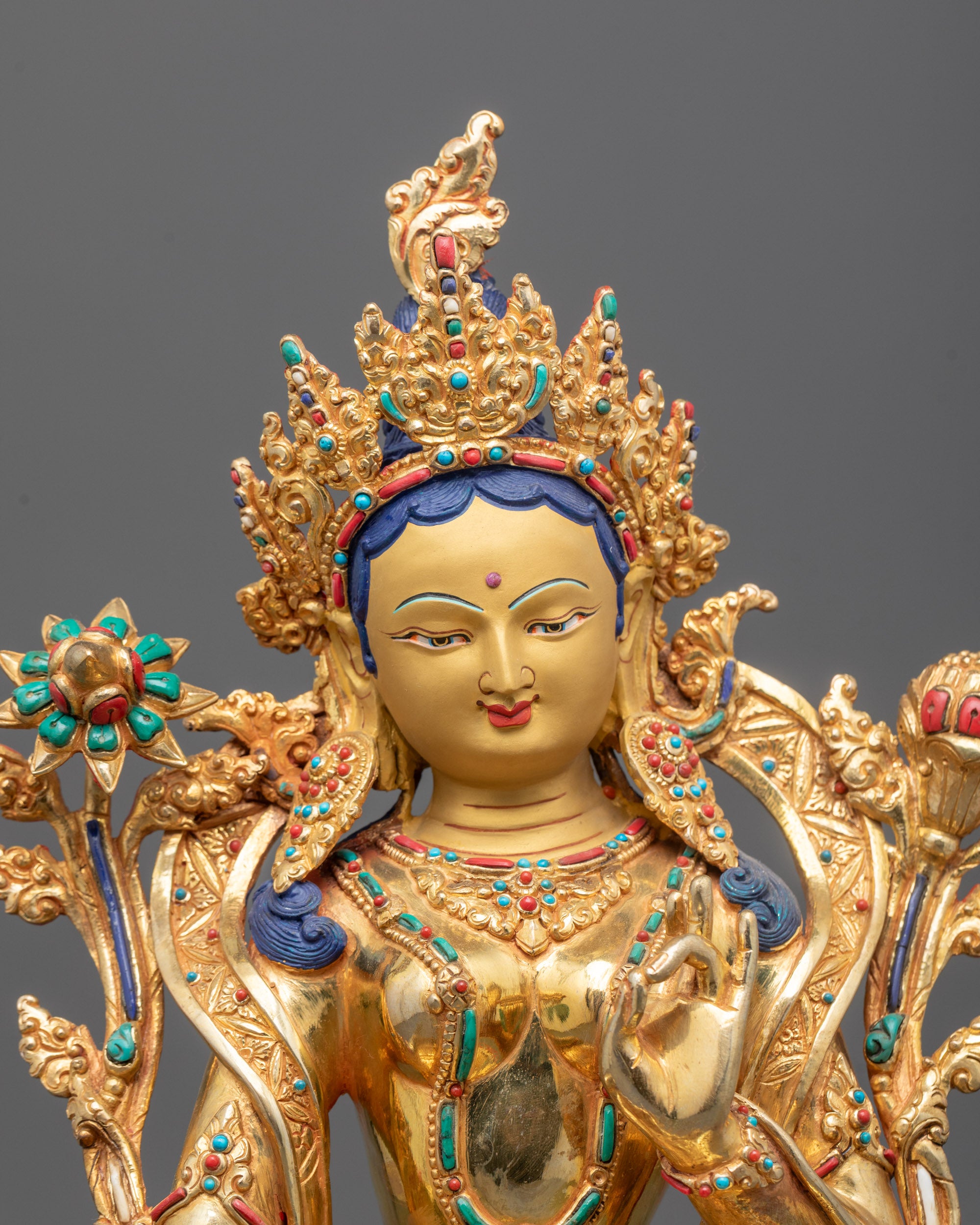 Close-up of Green Tara’s serene face and lotus flower symbol