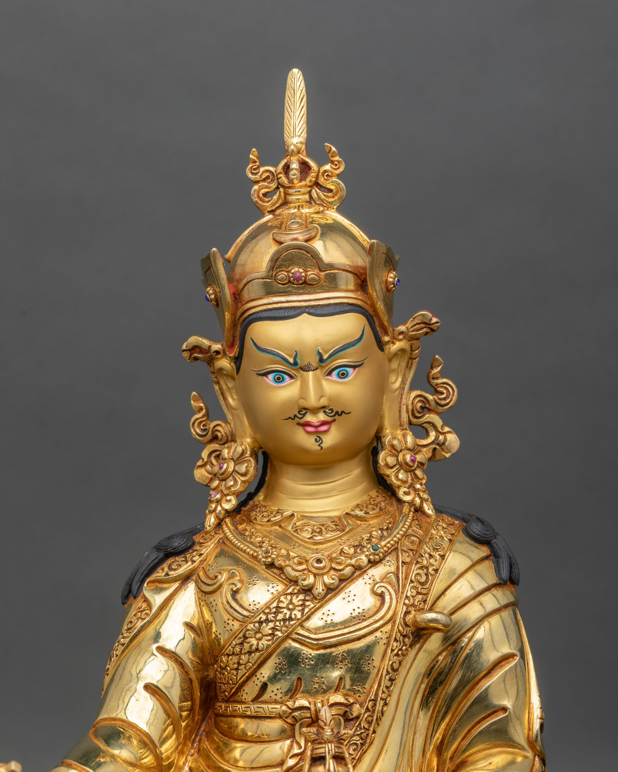 Close-up of Guru Padmasambhava statue showing intricate copper and gold details