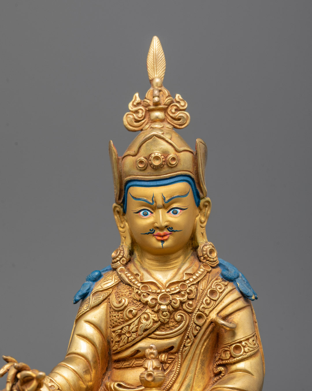 Close-up of Guru Rinpoche Statue Face with Intricate Gold Detailing