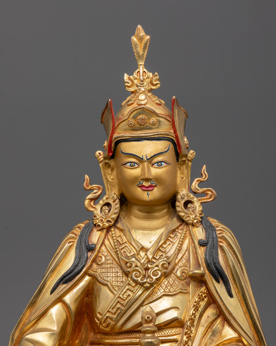 Close-up of Guru Rinpoche Statue showing detailed gold fire-gilded body and face.