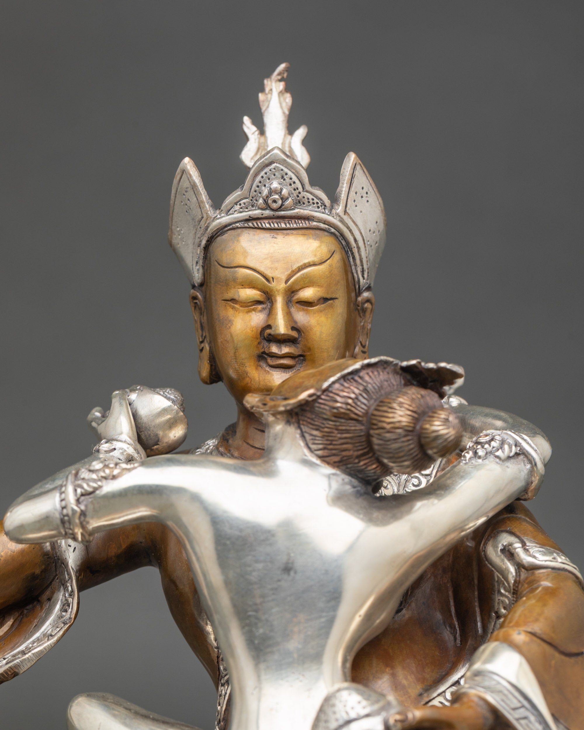Close-up of Guru Rinpoche’s semi-wrathful face holding vajra and kapala
