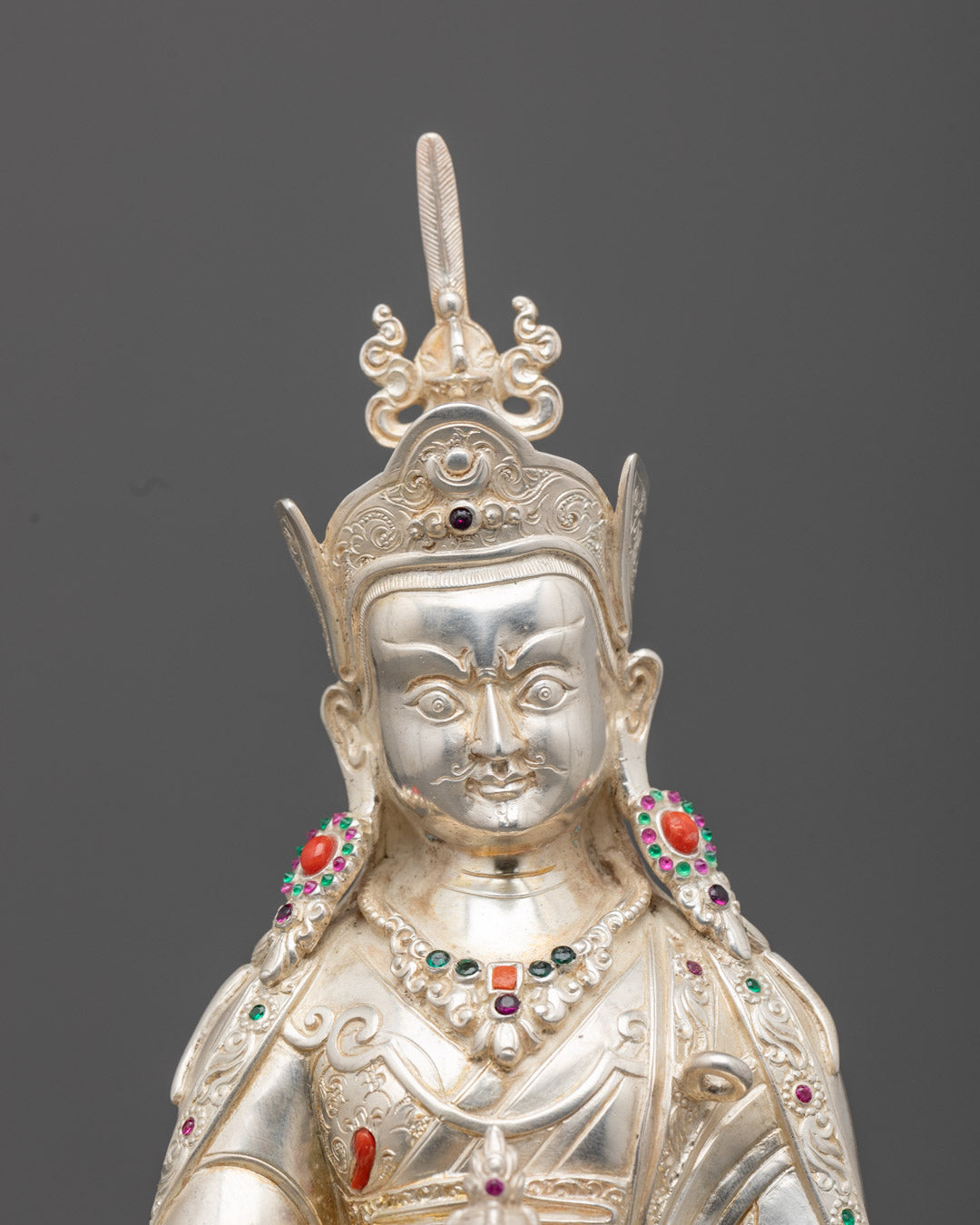 Guru Rinpoche sculpture showing intricate silver work, vibrant acrylic colors, and detailed facial expression.