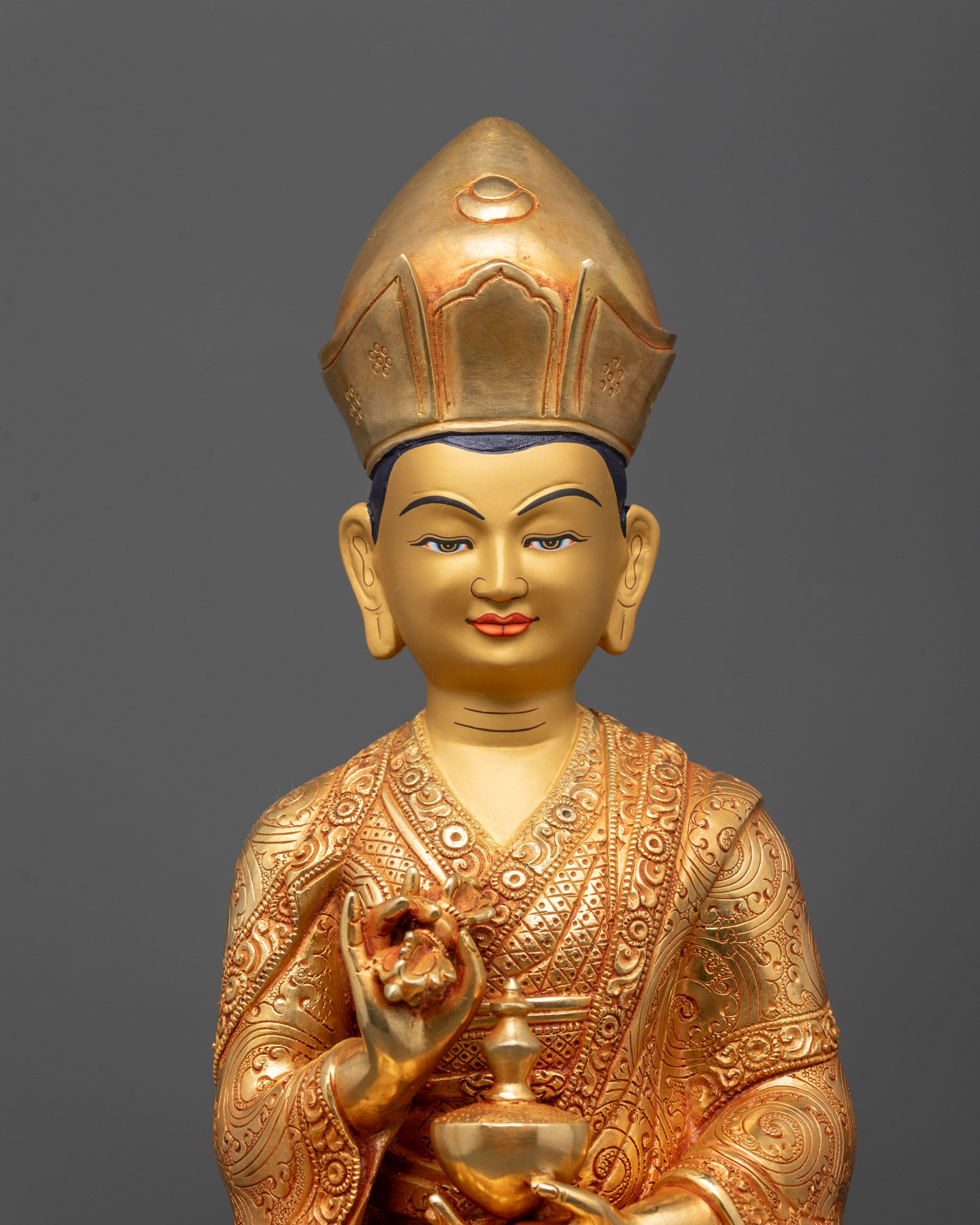 Close-up of Karmapa Statue’s serene face and vajra, highlighting 24k gold gilded details