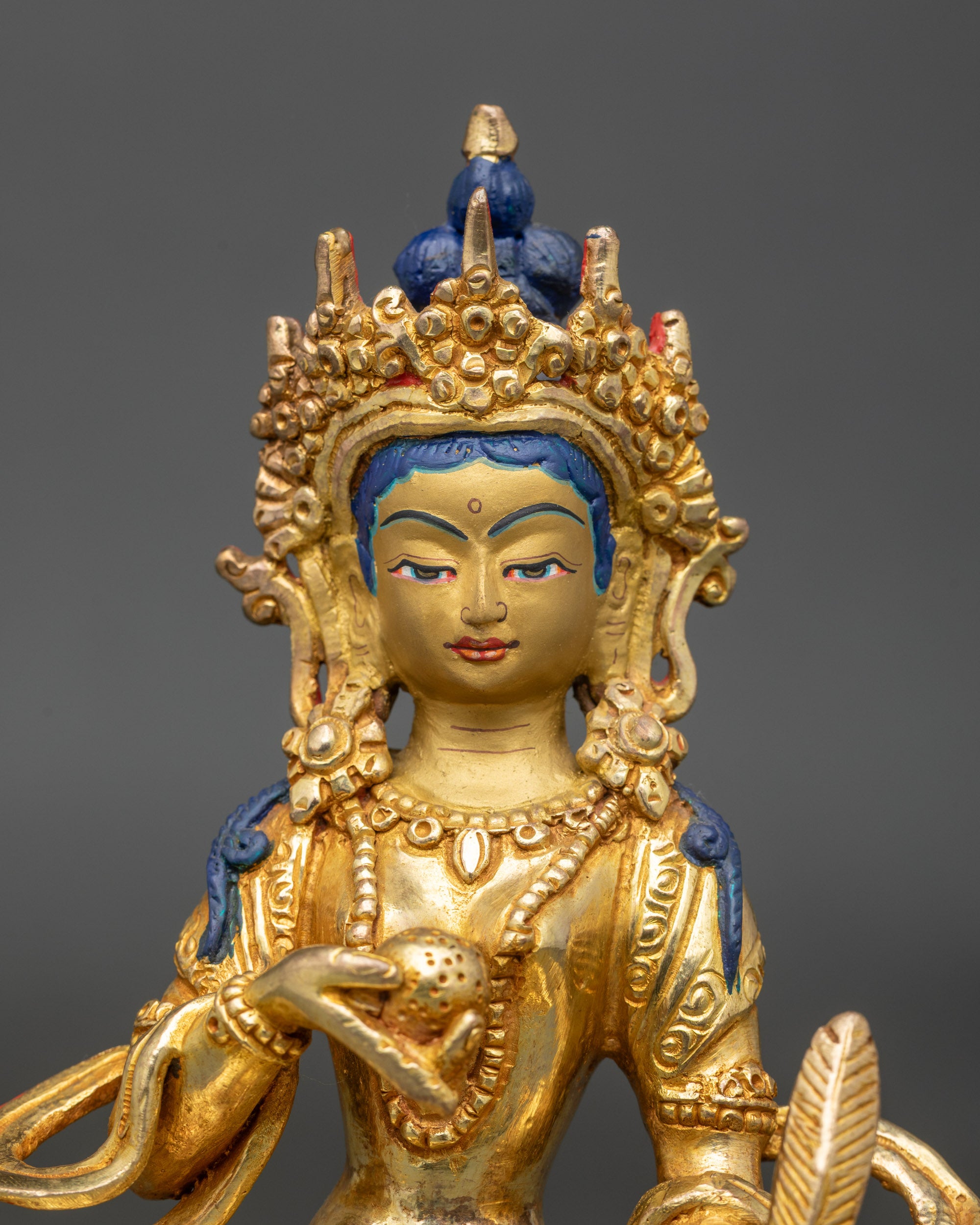 Close-up of Kshitigarbha statue face, 24k gold-painted, handcrafted Newari sculpture
