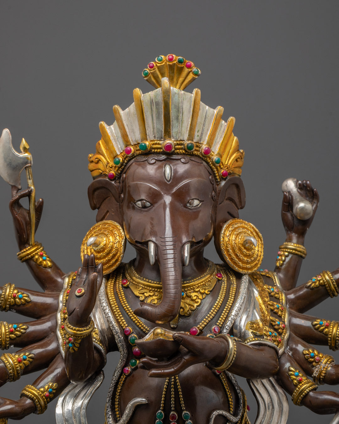 Close-up of Lord Ganesha's face and ornate crown with fine silver