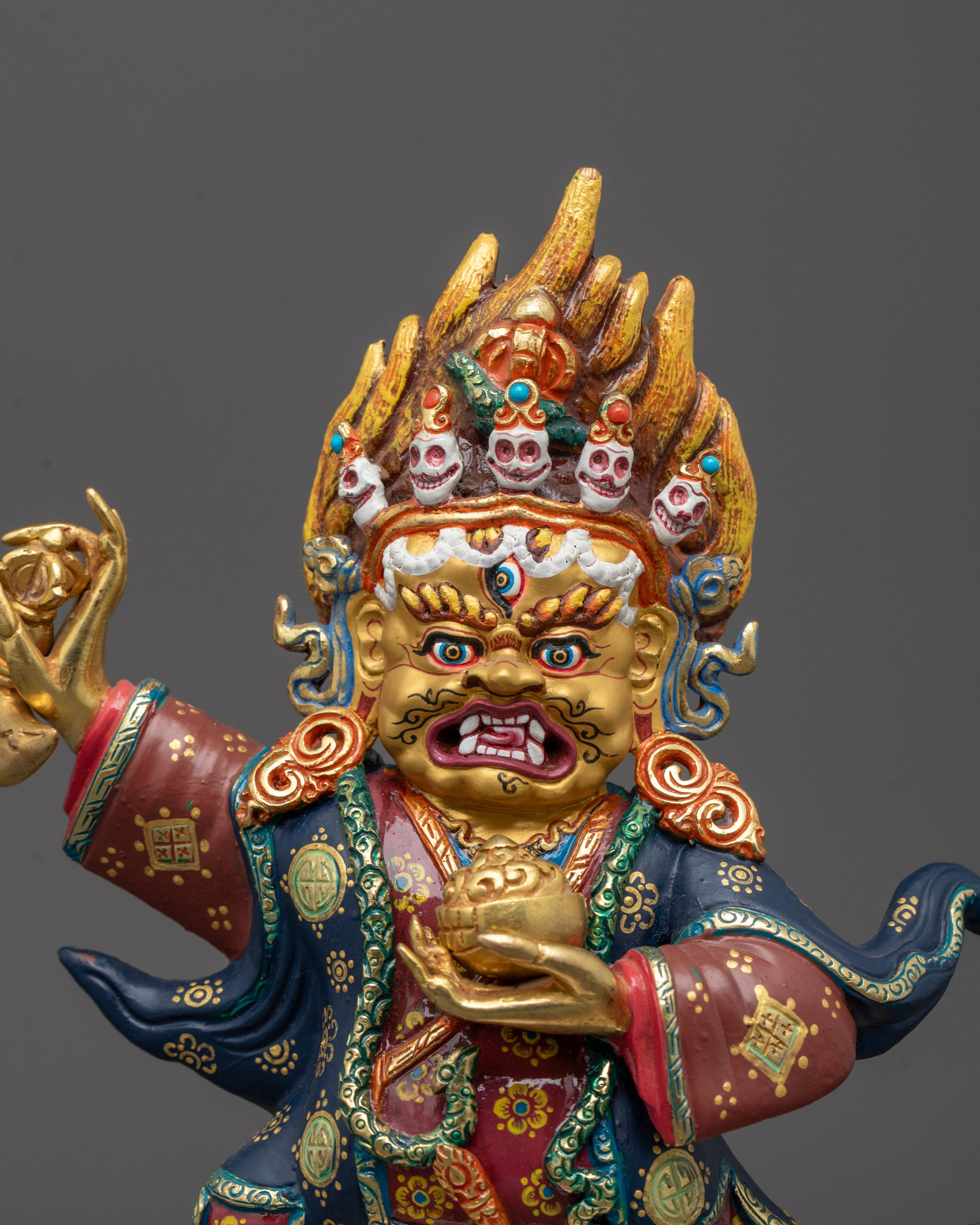 Close-up of Mahakala Bernagchen's wrathful face gilded with 24k gold,