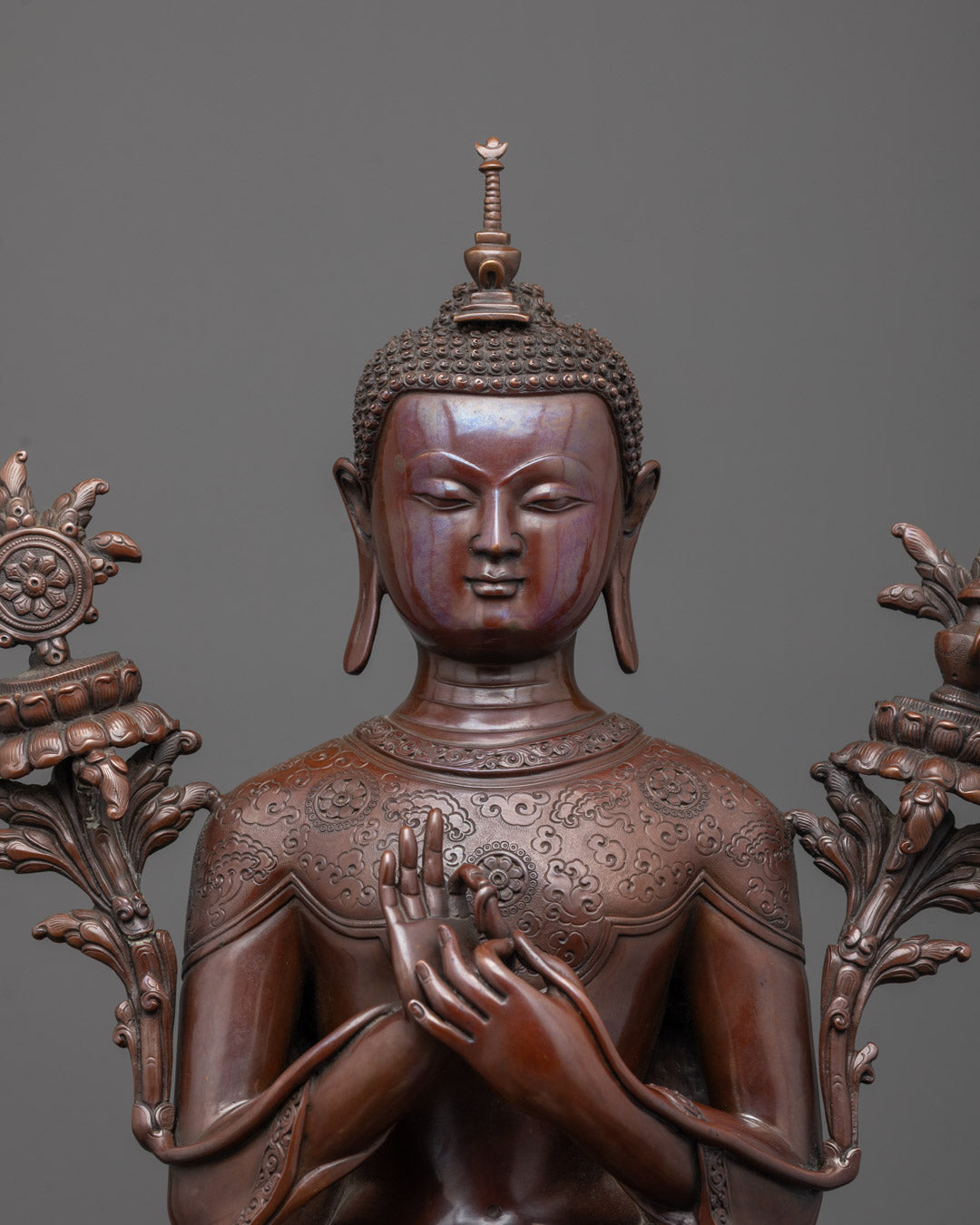 Close-up of Maitreya Buddha’s face and hand in teaching mudra with antique finish