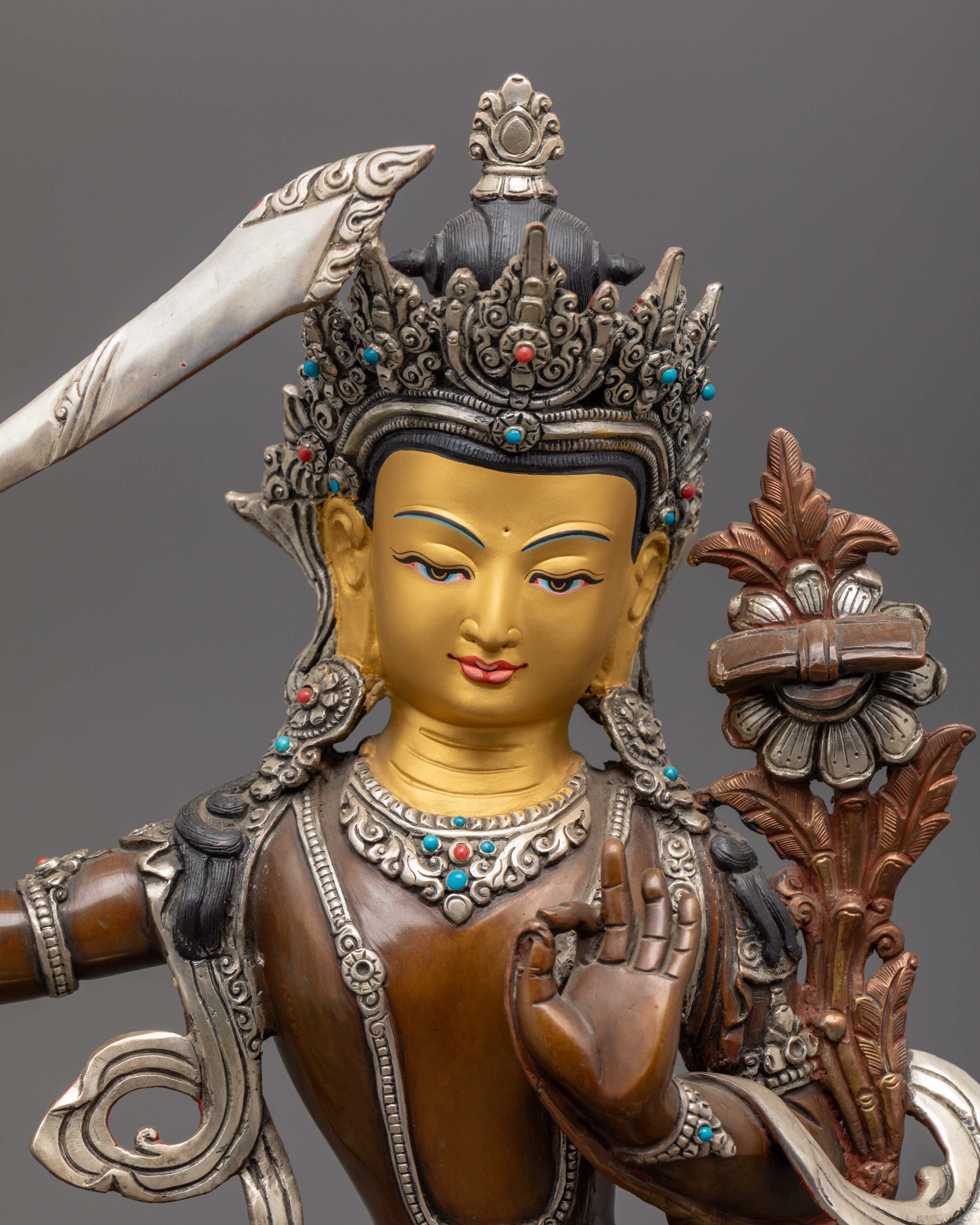 Manjushri Bodhisattva’s serene face adorned with gold accents and detailed crown