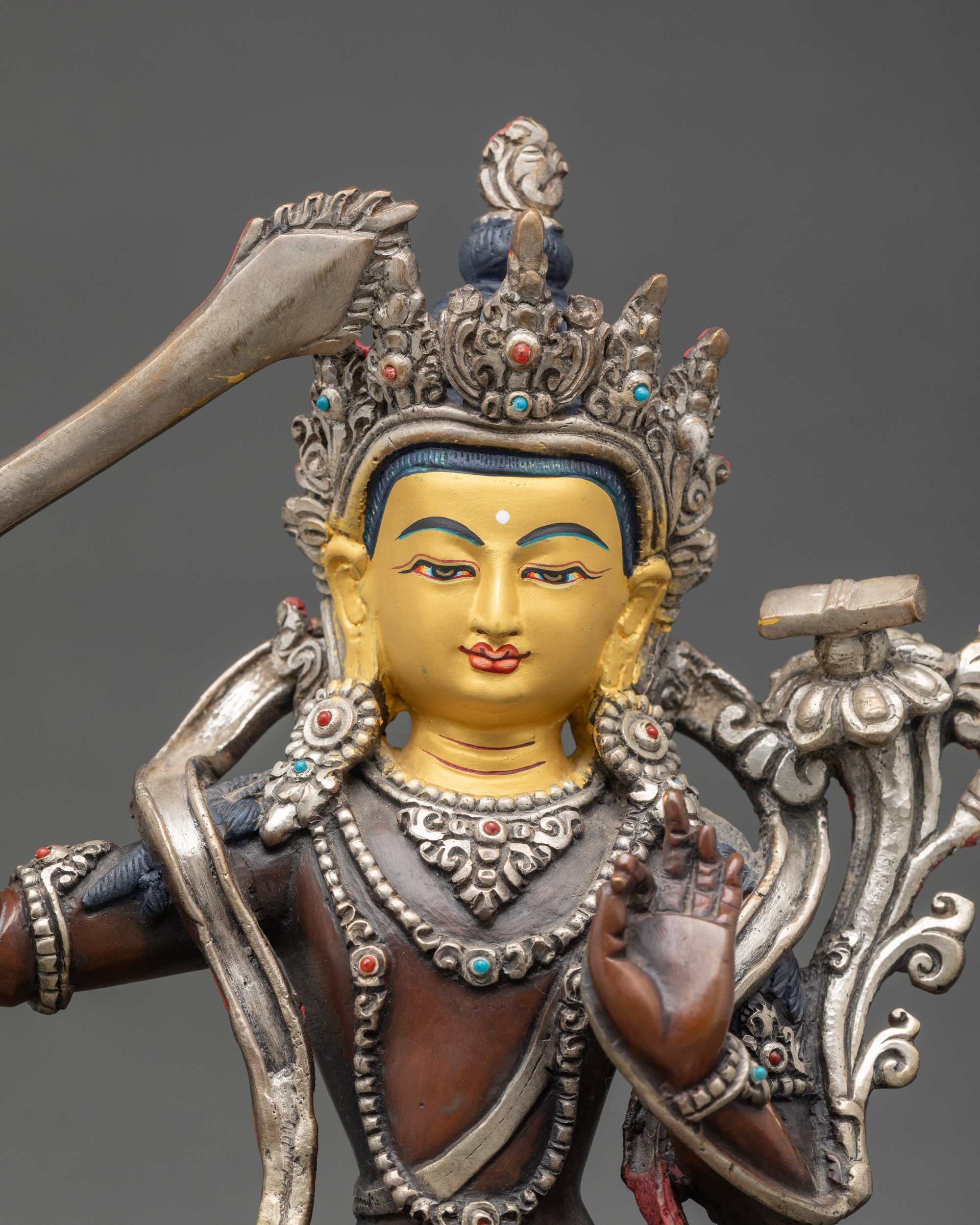 Close-up of Manjushri Bodhisattva sword and intricate silver-plated details
