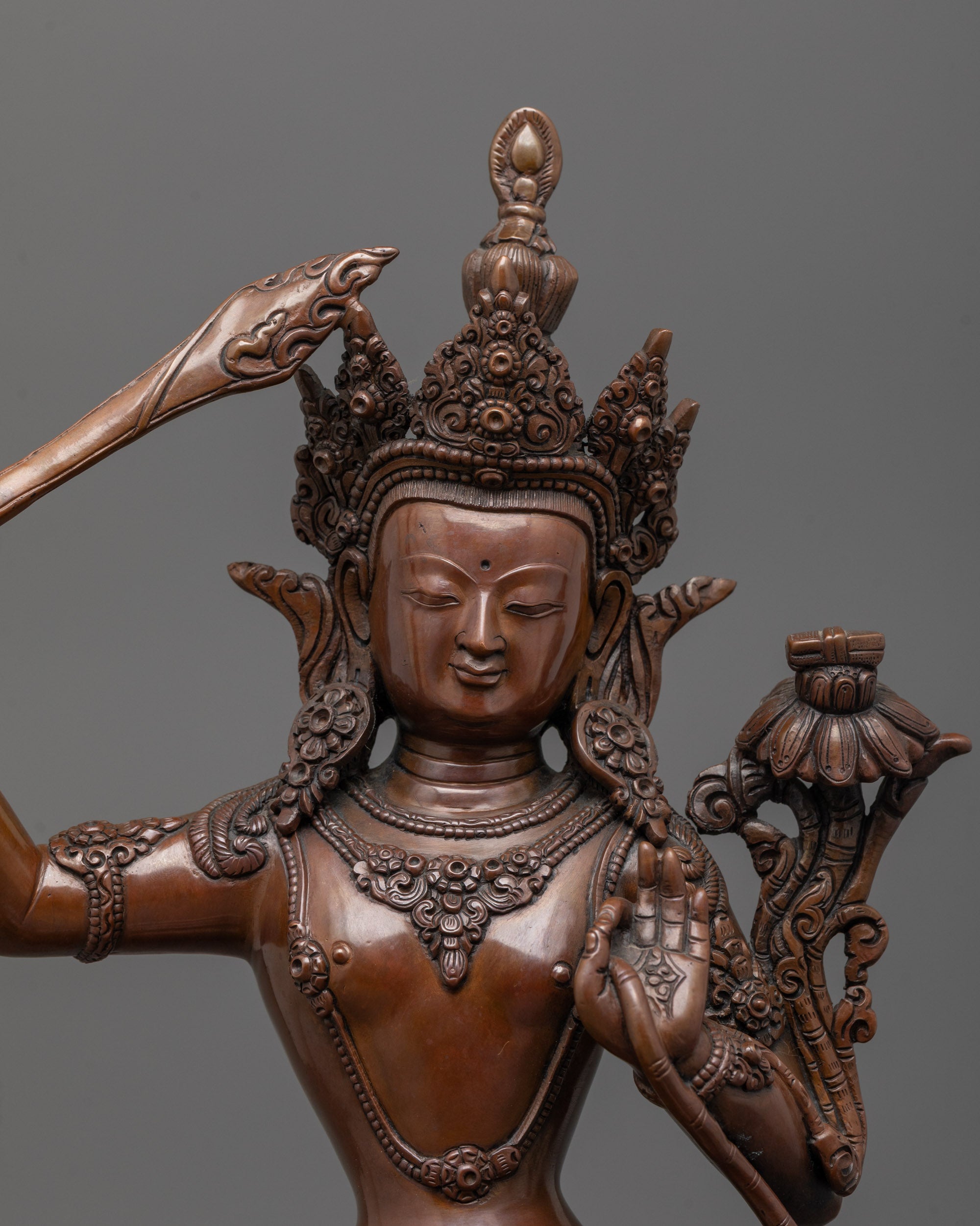 Close-up of Manjushri Statue face with oxidized copper finish and fine detailing