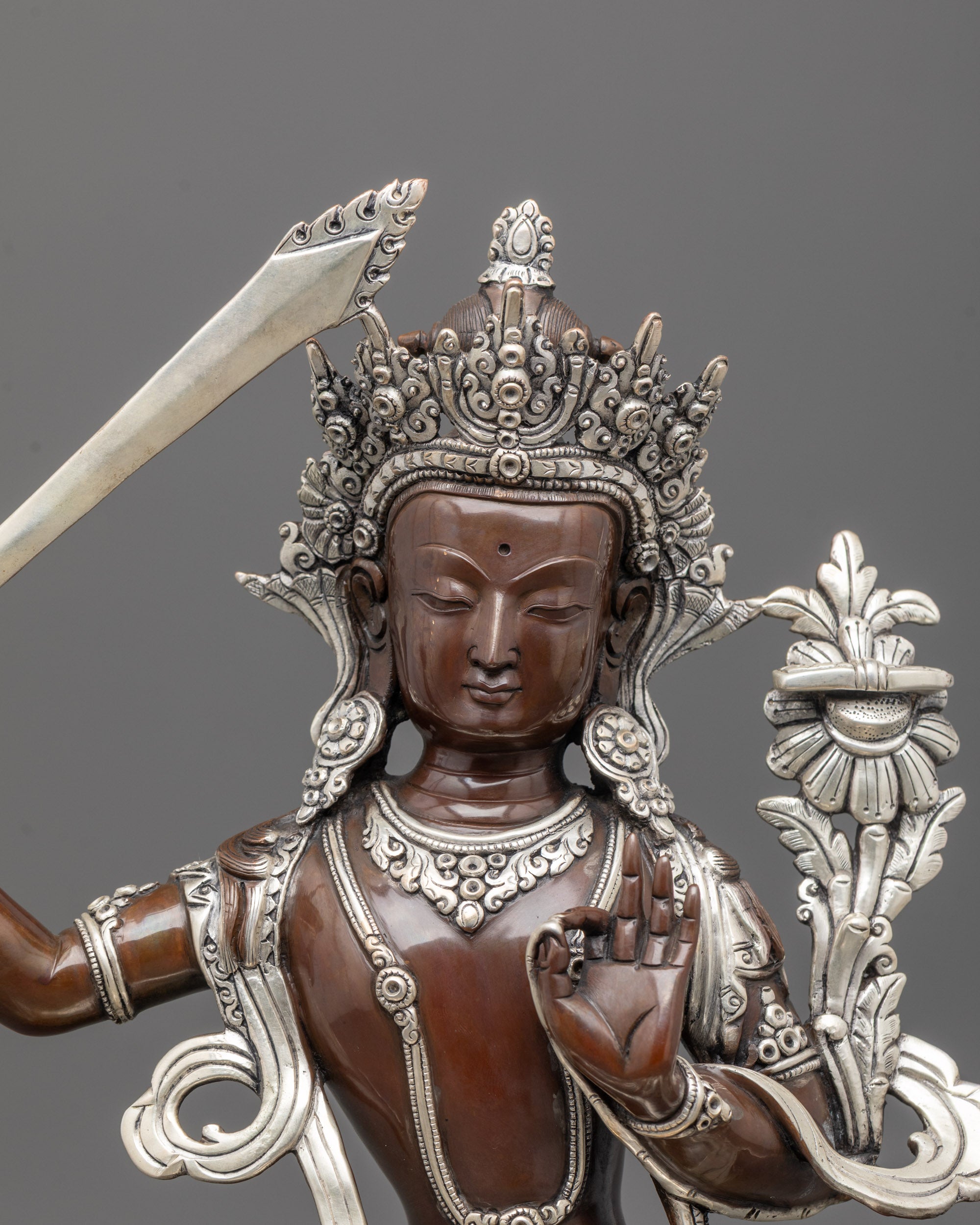Close-up of Manjushri statue’s silver-plated sword, crown, and intricate carvings