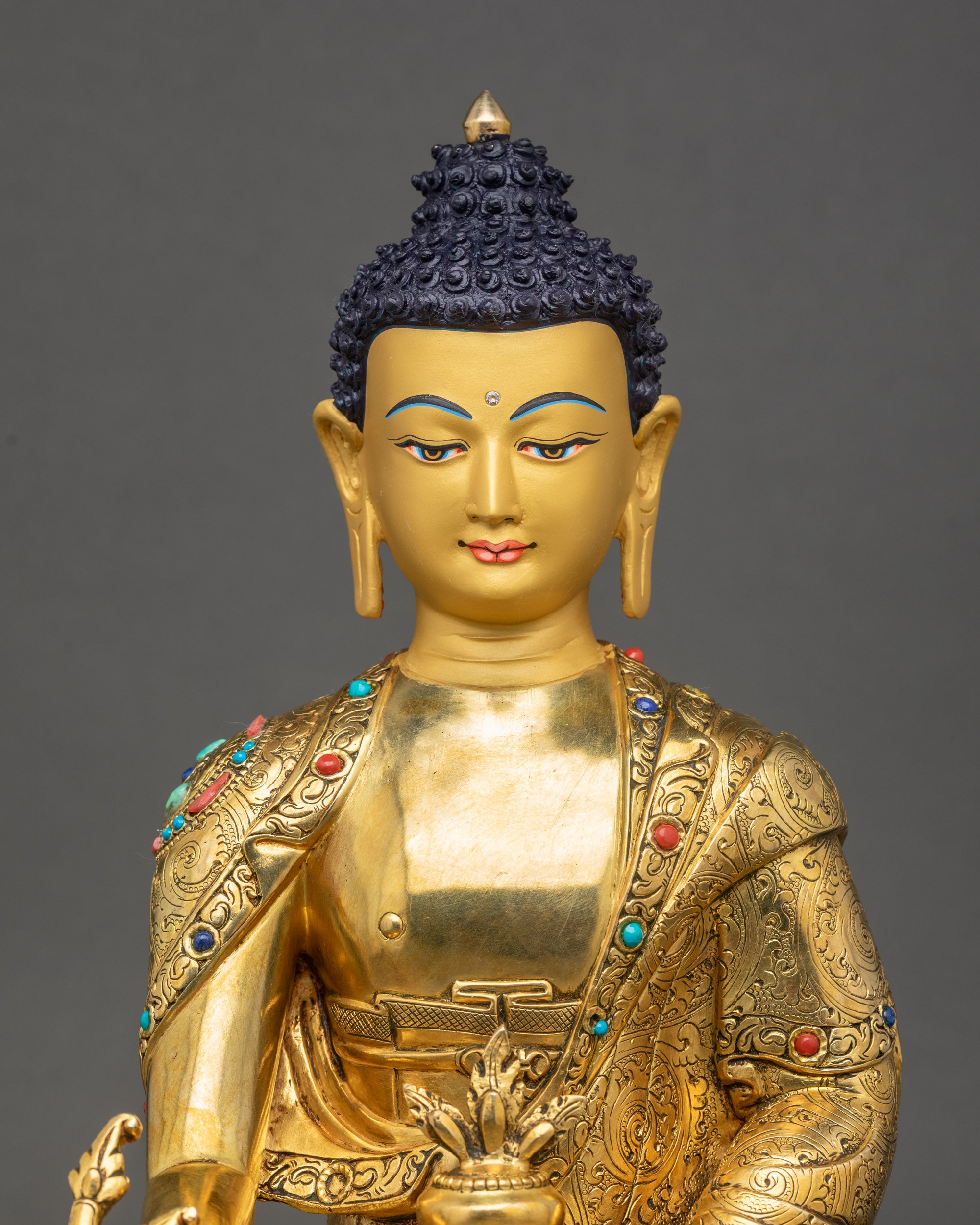 Close-up of Medicine Buddha Statue Nepal showing gold-gilded face and detailed monk’s robe