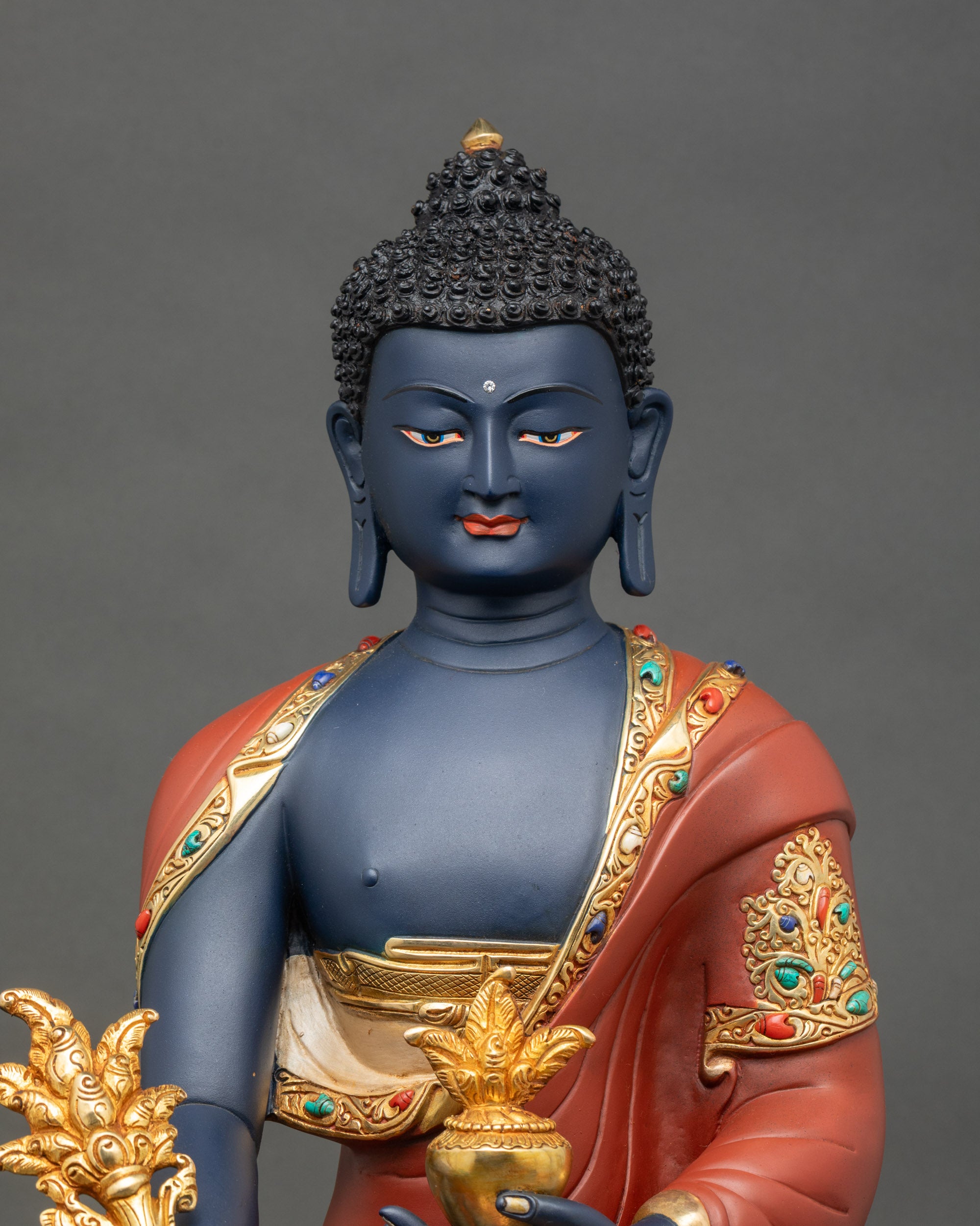 Close-up of Medicine Buddha figurine showing intricate copper and gold details for meditation