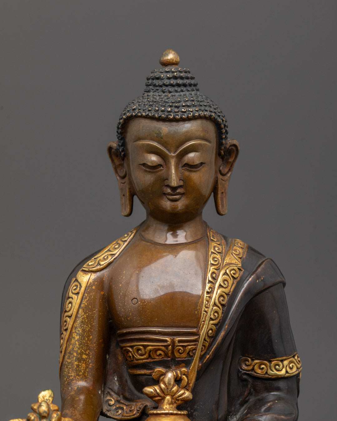 Close-up of Medicine Buddha’s serene face and crown, symbolizing healing energy