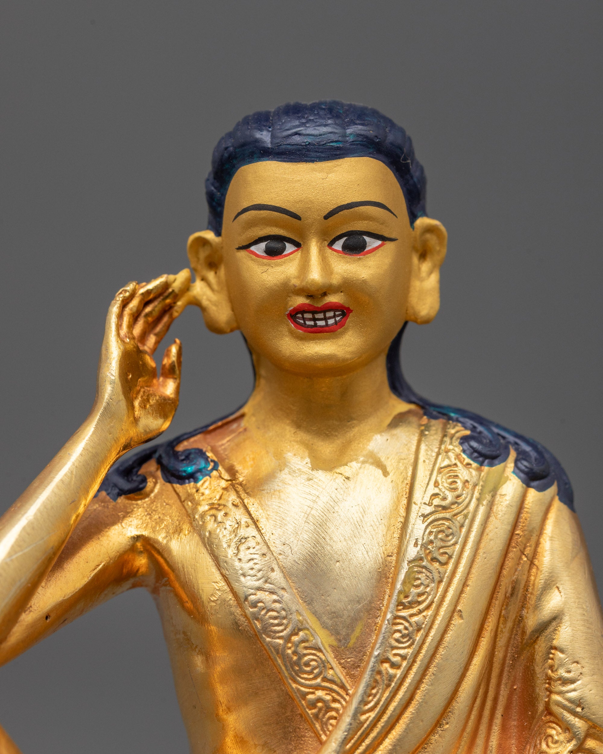 Close-up of Milarepa Statue’s serene face showing detailed gold plating