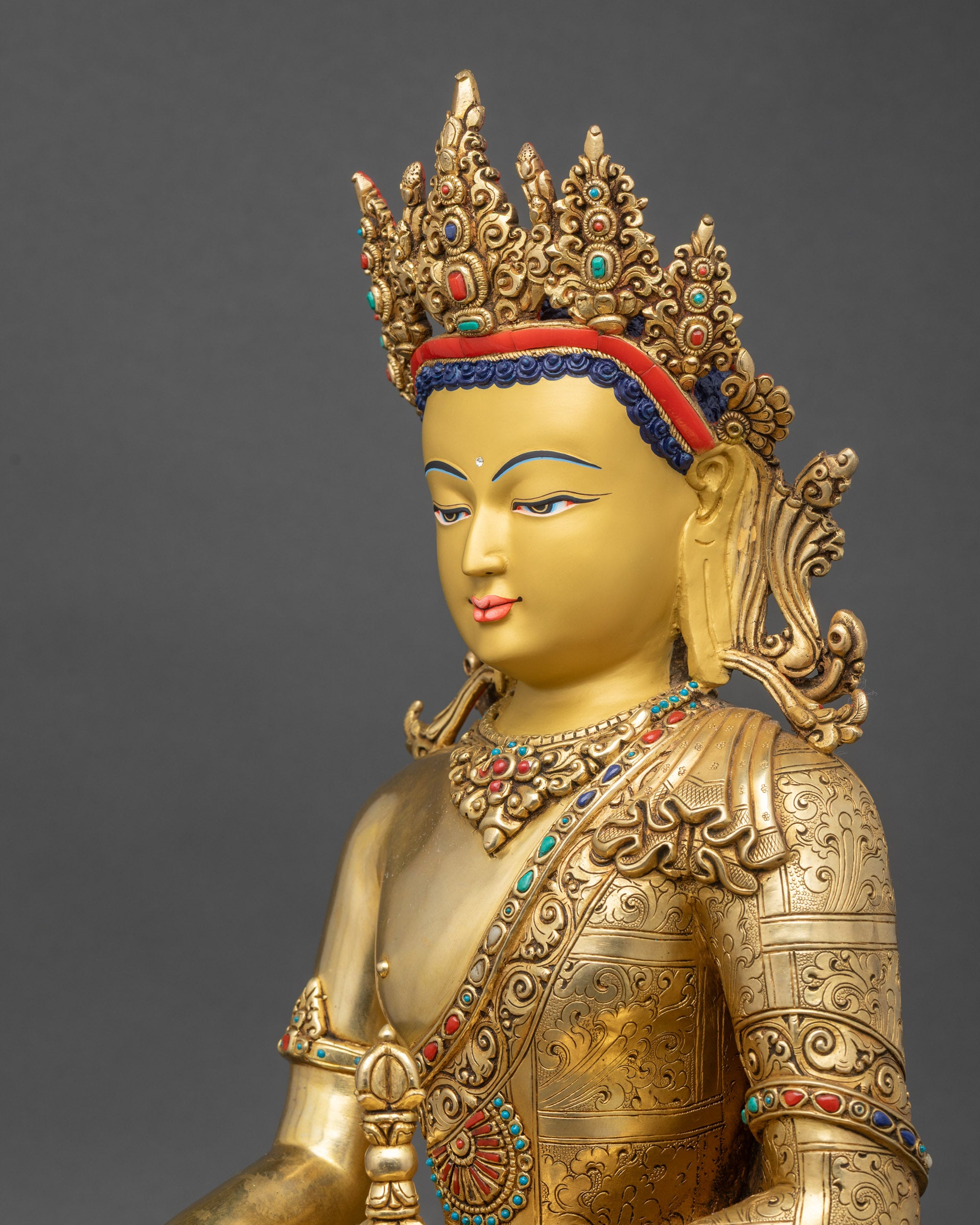 Close-up of Mitrugpa statue side showing gold fire-gilding and carved robe details.