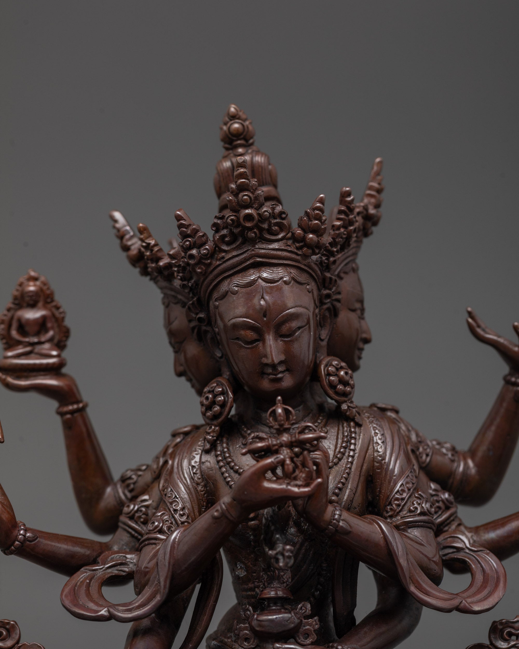 Close-up of Namgyalma statue’s oxidized copper face showing three faces and intricate craftsmanship