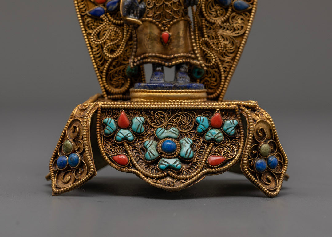 Close-up of Padmapani Bodhisattva statue featuring 24k gold gilding and stunning blue gemstone body