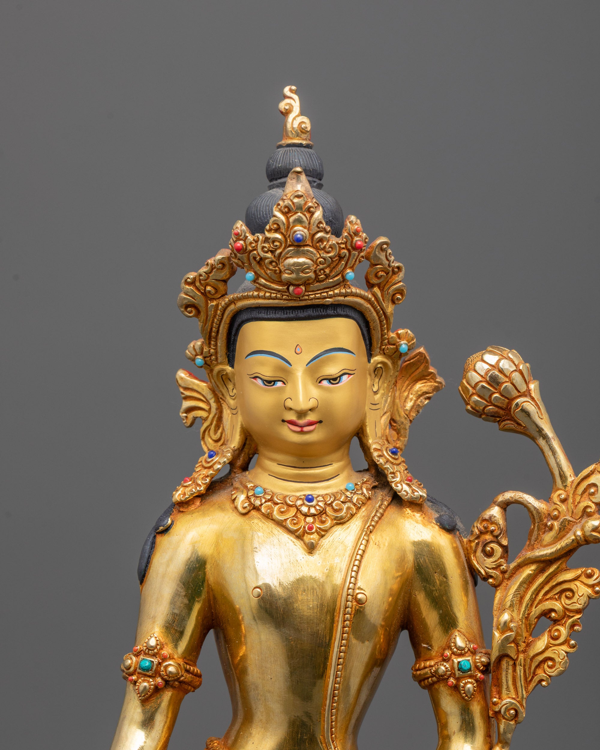 Close-up of Padmapani's peaceful face with golden crown and detailed copper body
