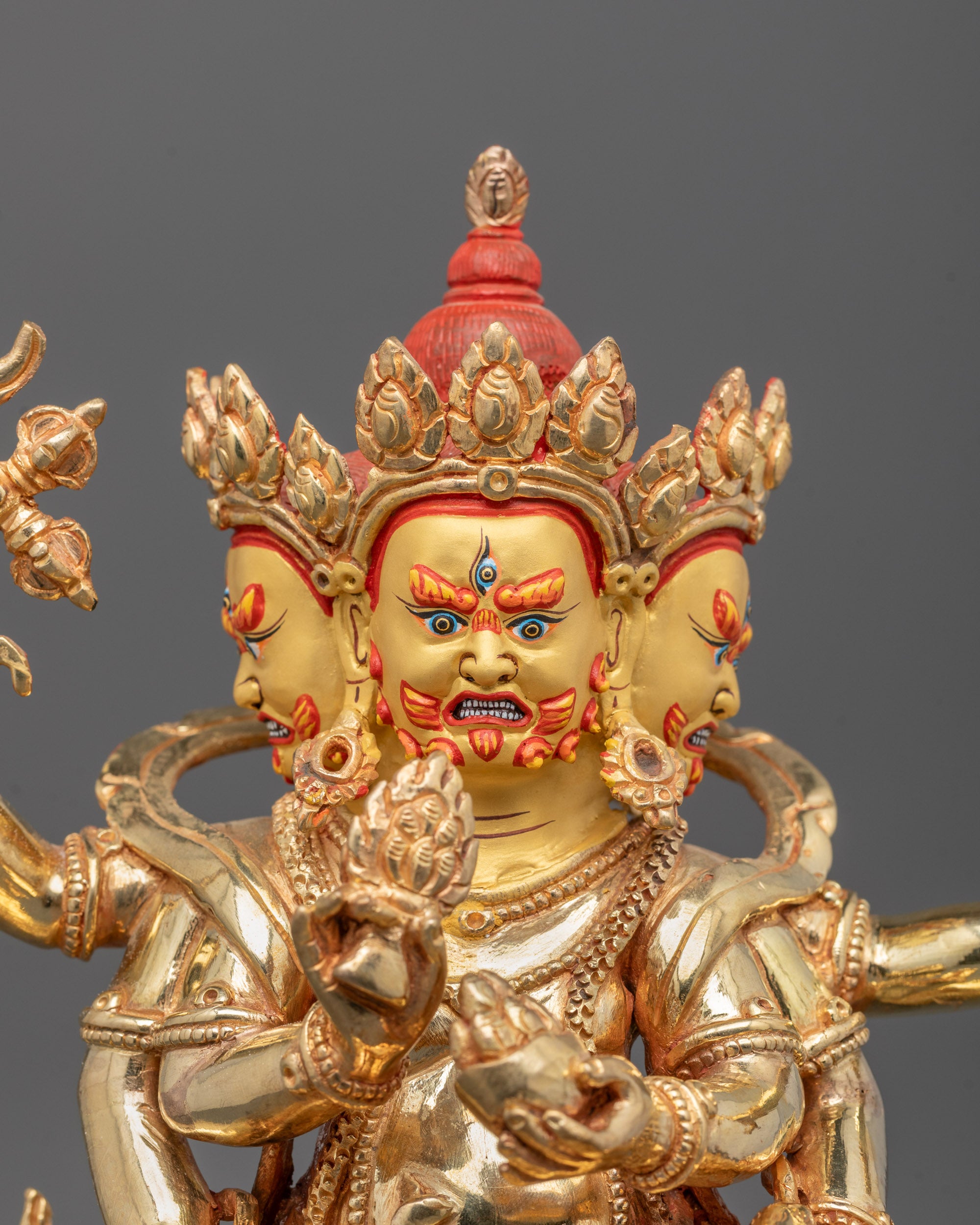 Close-up of Red Dzambhala’s gold-plated copper body showing fierce expression