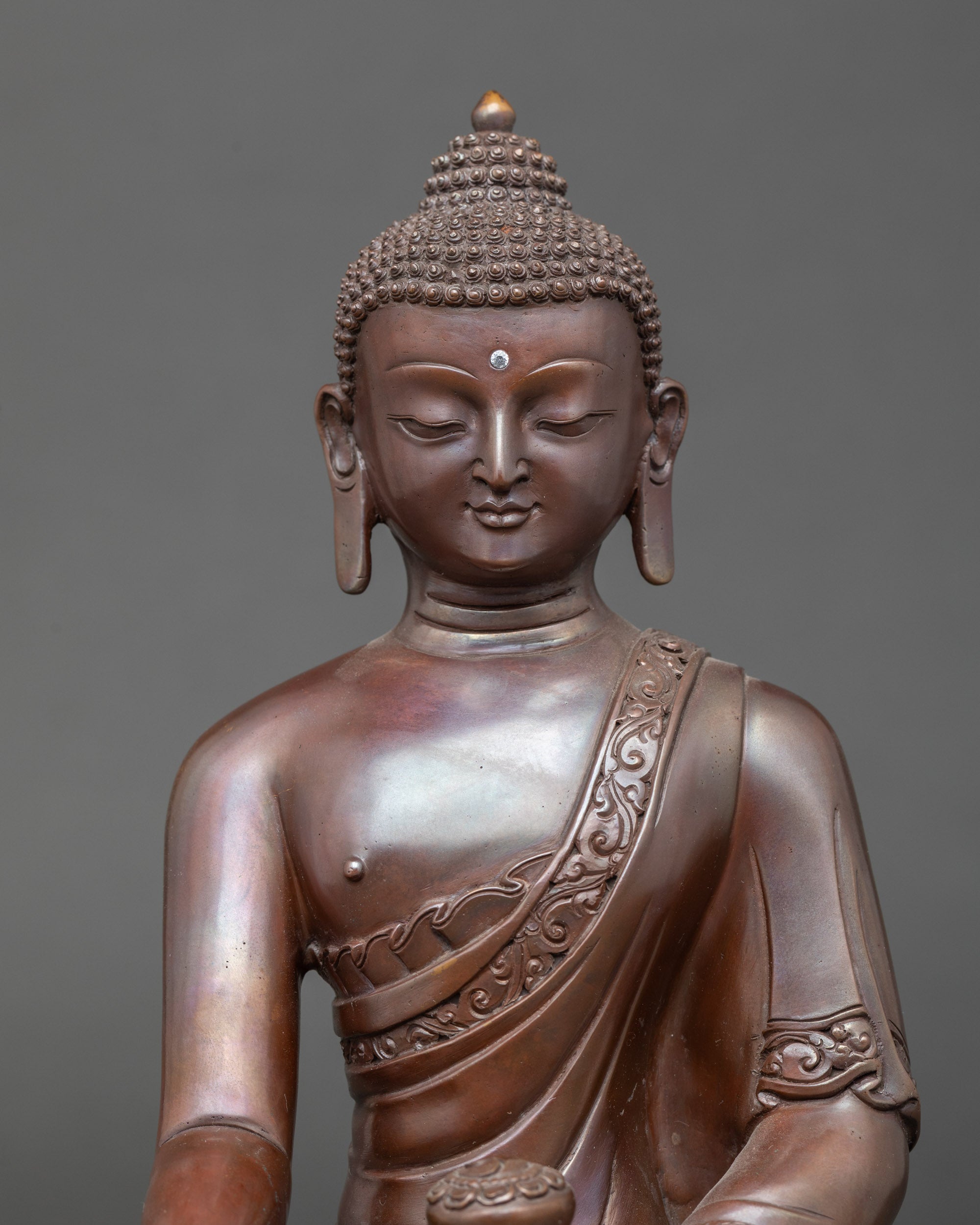 Close-up of Shakyamuni Buddha face, chemically oxidized copper with serene expression