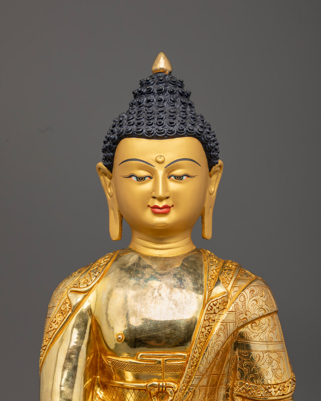 Close-up of Shakyamuni Buddha's serene expression adorned with semi-precious stones and acrylic detailing