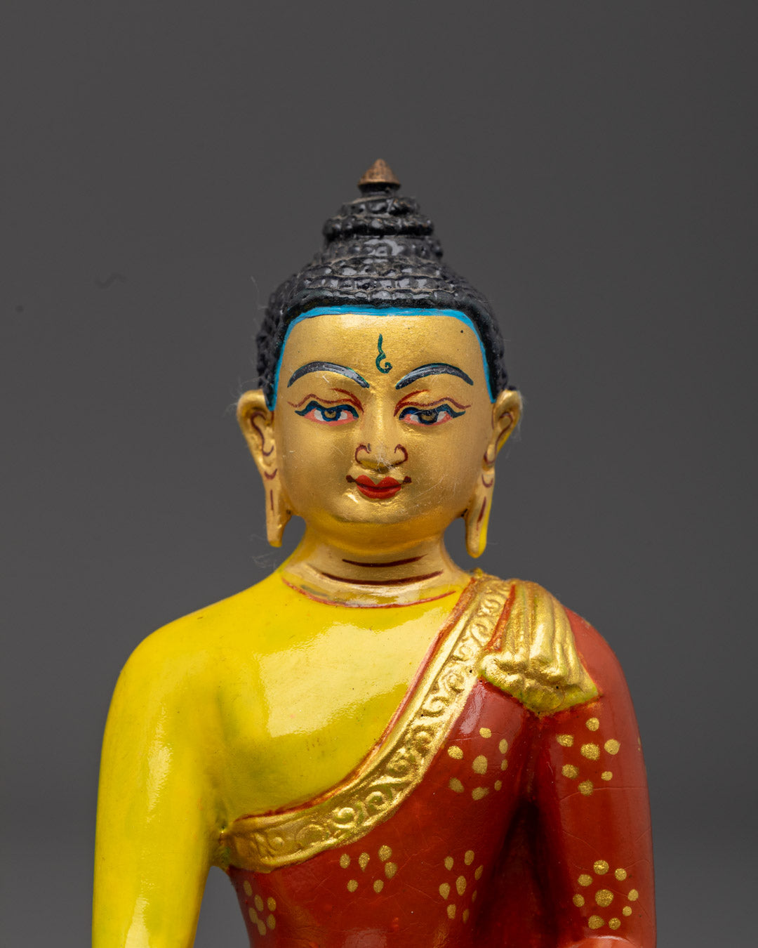 Shakyamuni Buddha statue’s serene face and right hand in Bhumisparsha Mudra, symbolizing enlightenment and victory over Mara.