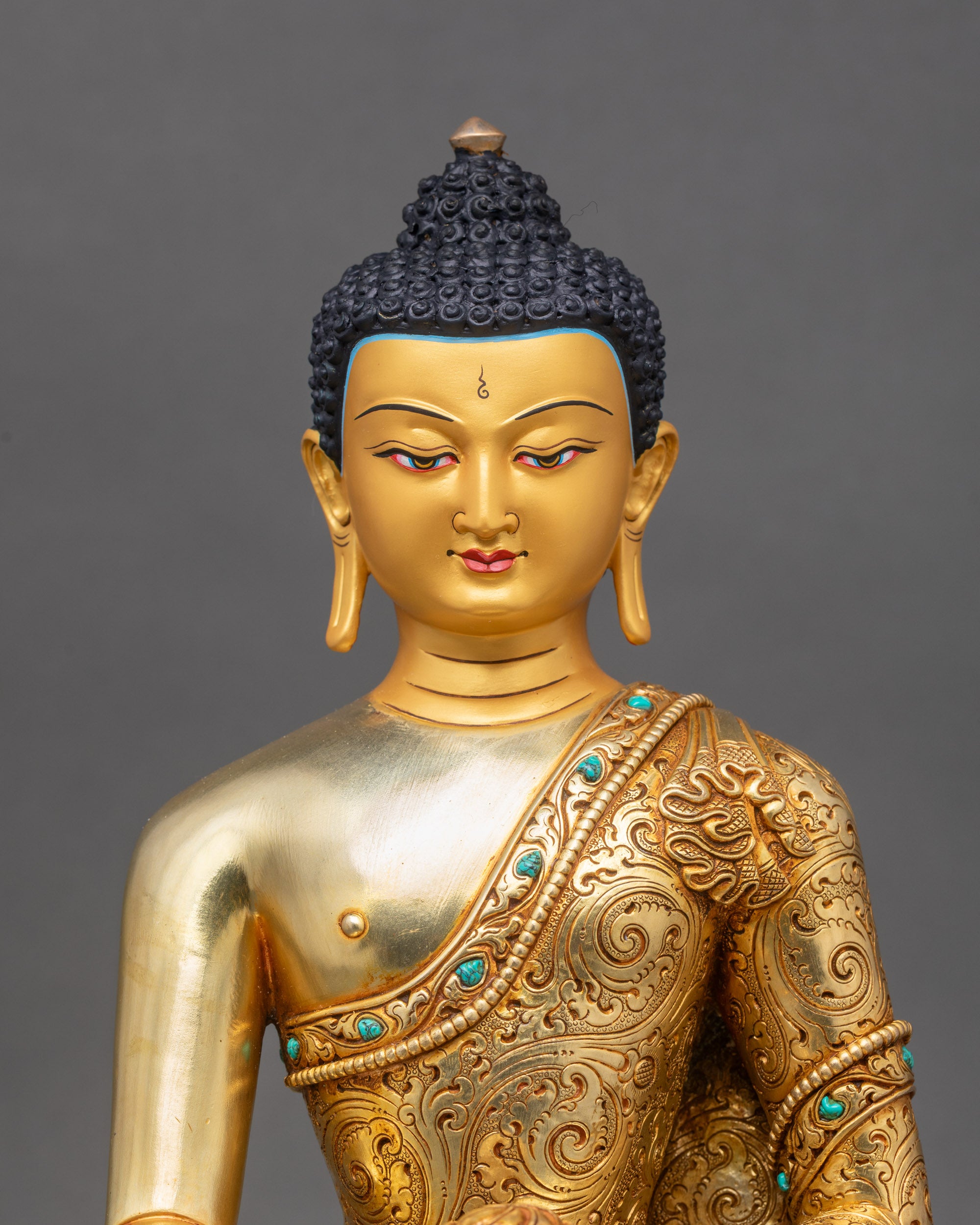 Close-up of Shakyamuni Buddha statue showing gold finish and intricate robe details