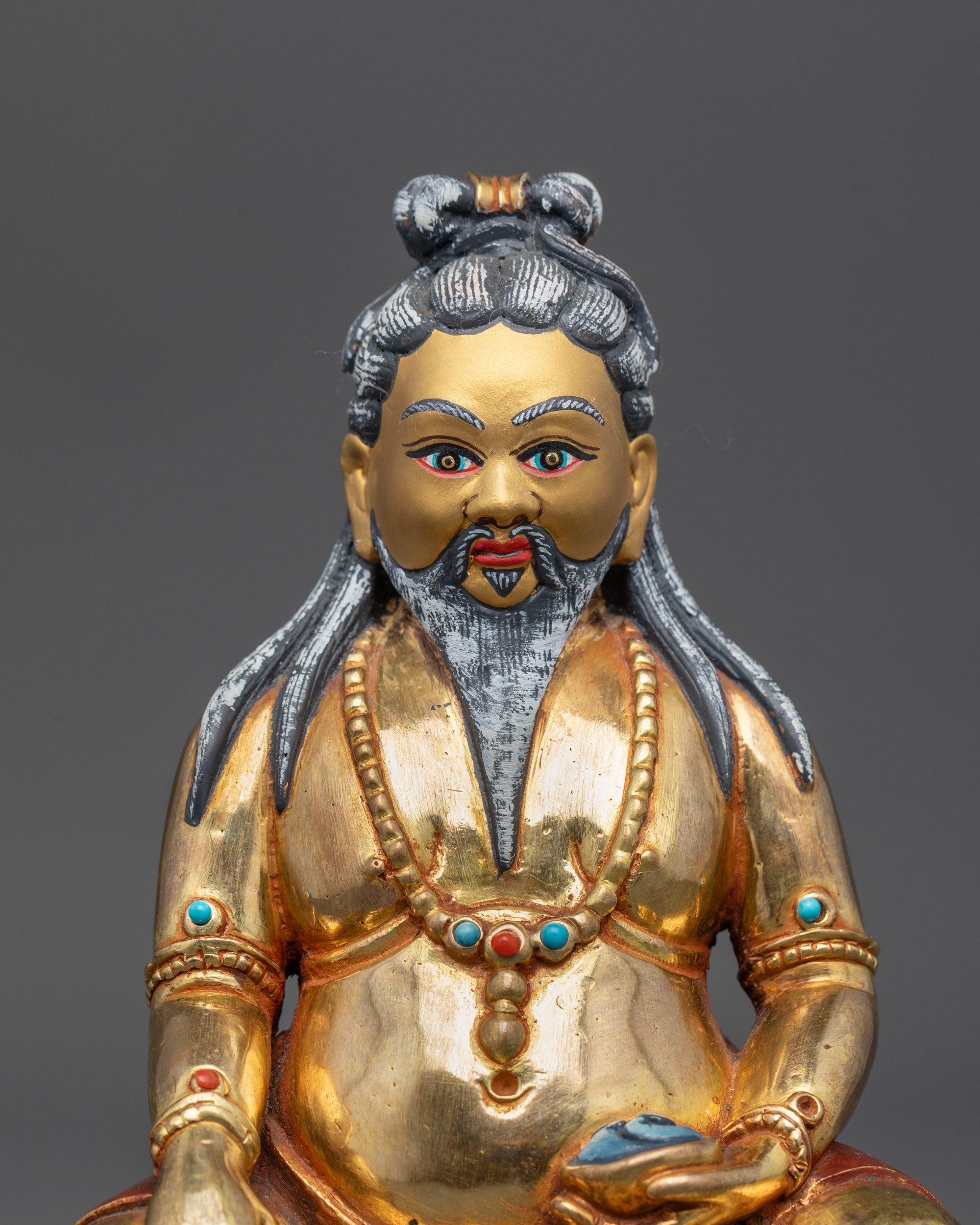 Close-up of Thangtong Gyalpo face showing white hair, beard, and gold-gilded details