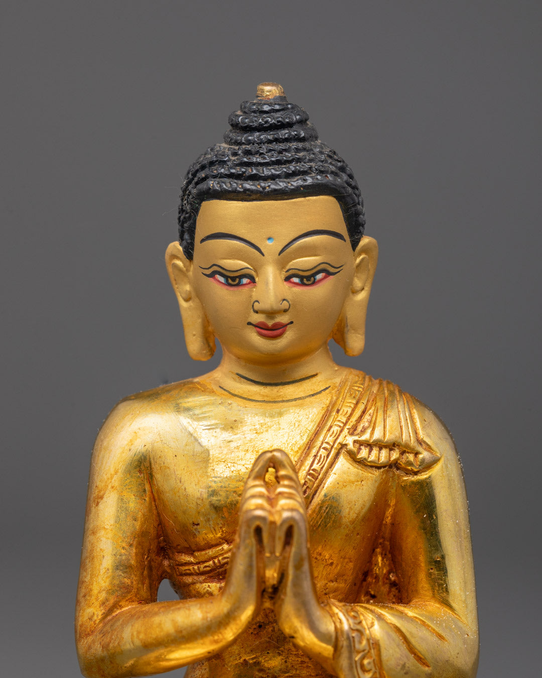 Close-up of Vairocana Buddha’s gold Fire-gilded body seated on chos khri throne with mudra pose.
