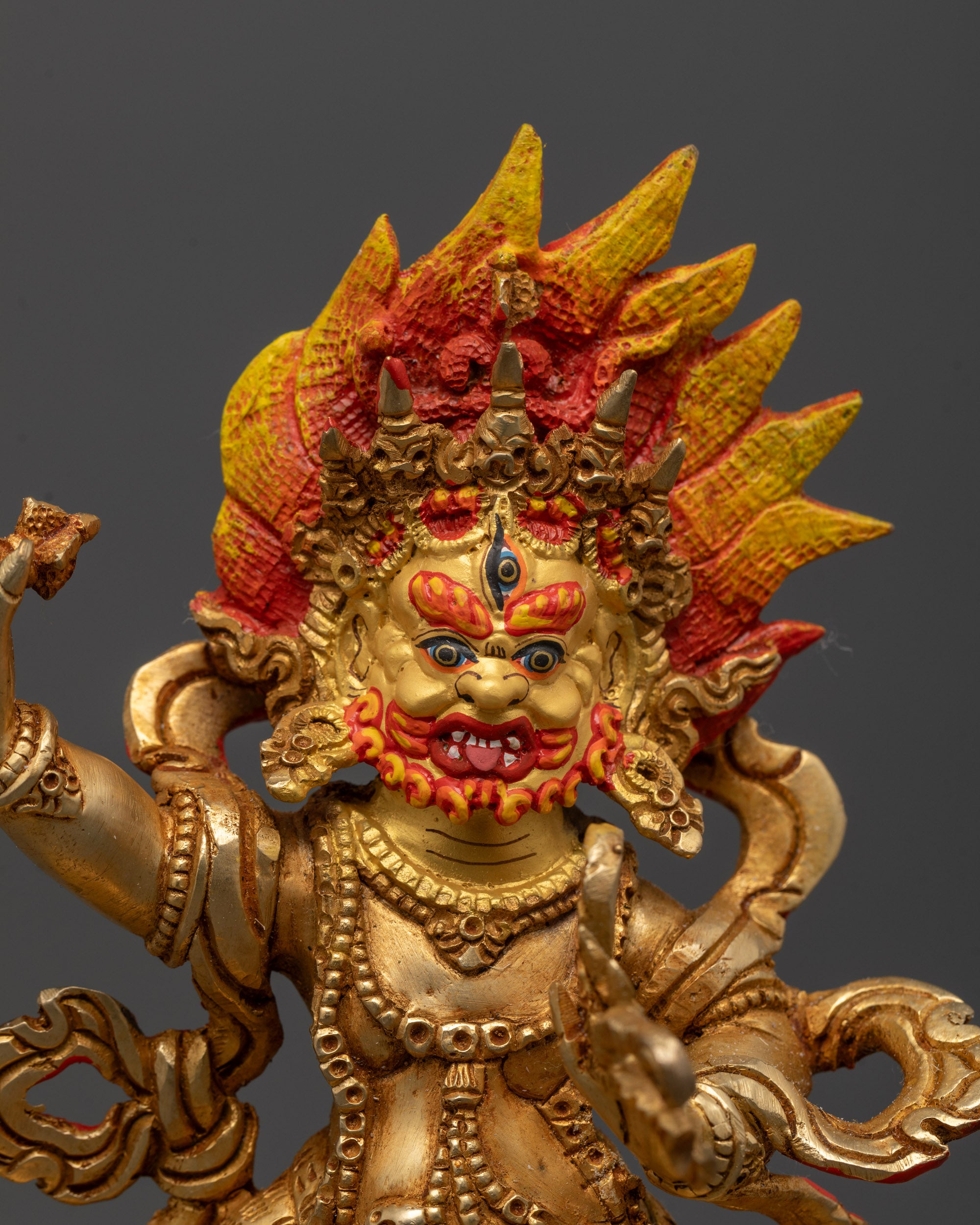 Close-up of Vajrapani’s fierce face with radiant halo and intricate gold gilding