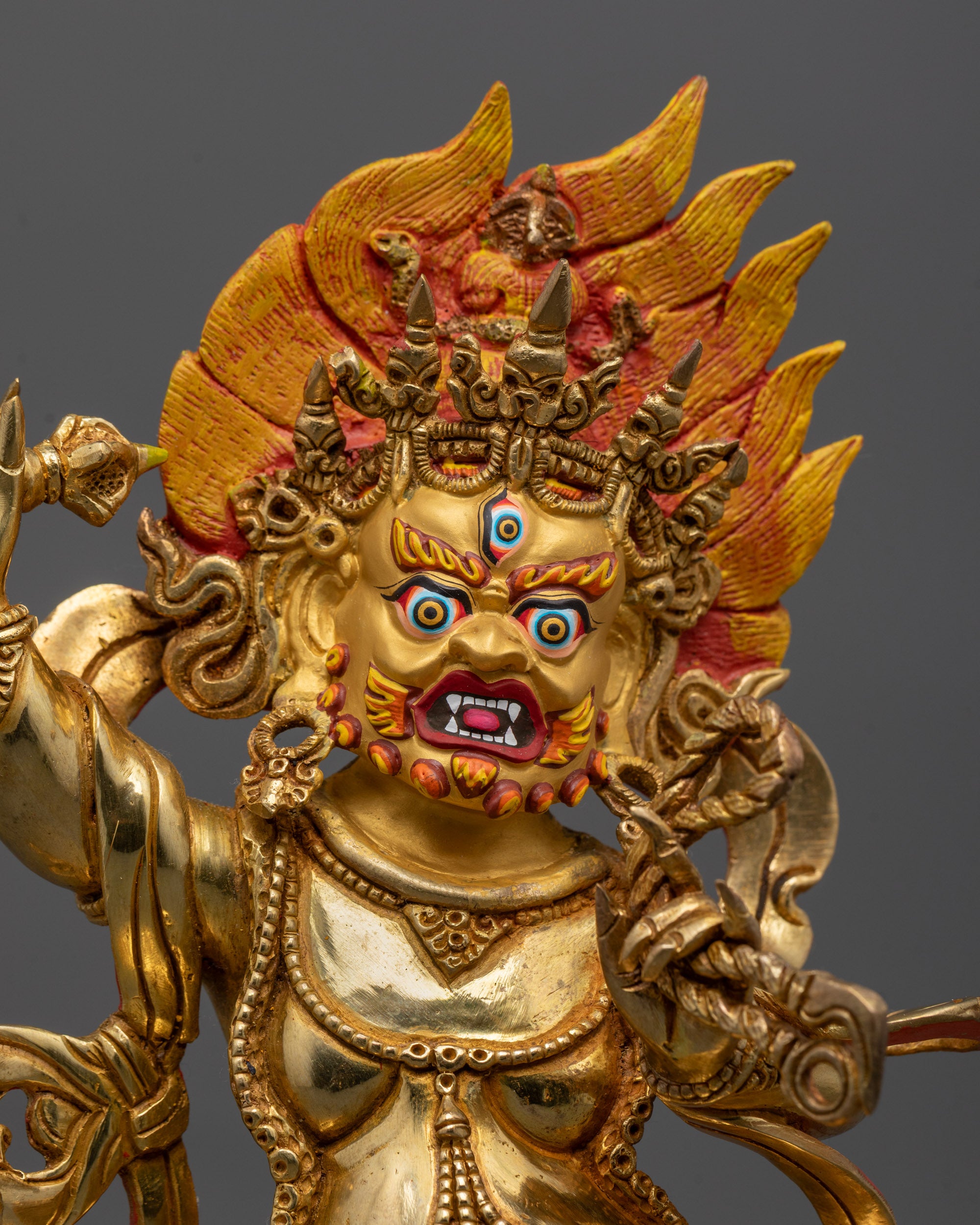 Close-up of Vajrapani's wrathful expression and 24k gold-polished face