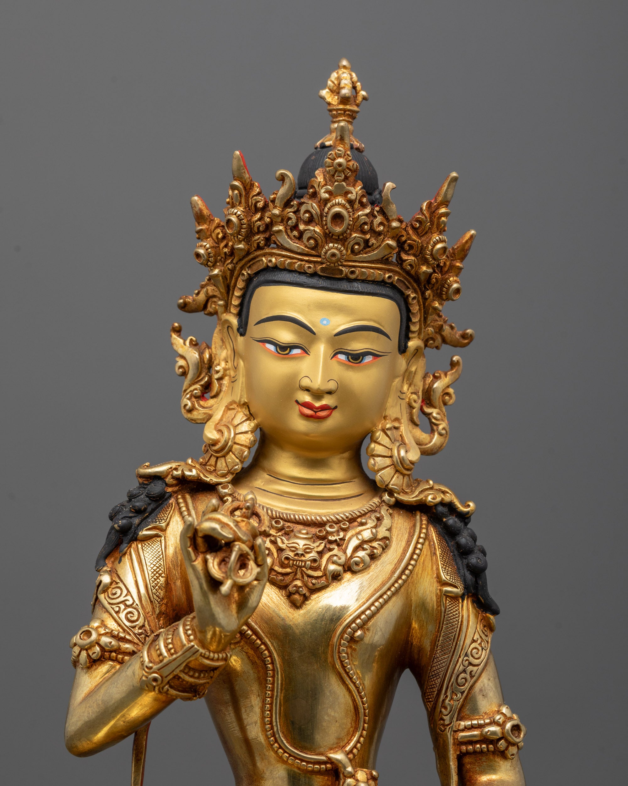 Close-up of Vajrasattva Statue showing intricate design and detailed vajra and bell in hands