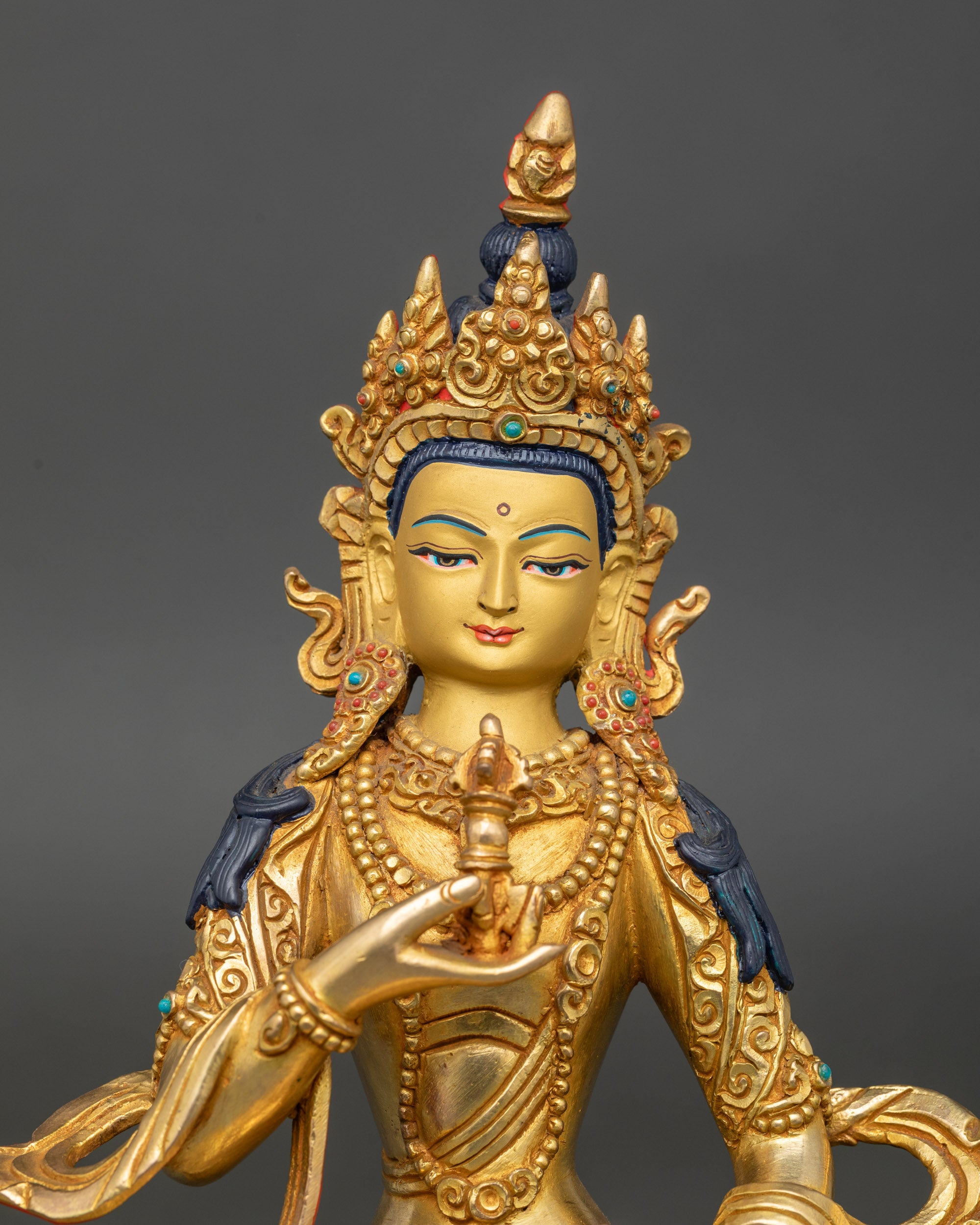 Close-up of Vajrasattva face showing serene expression and gold-painted details